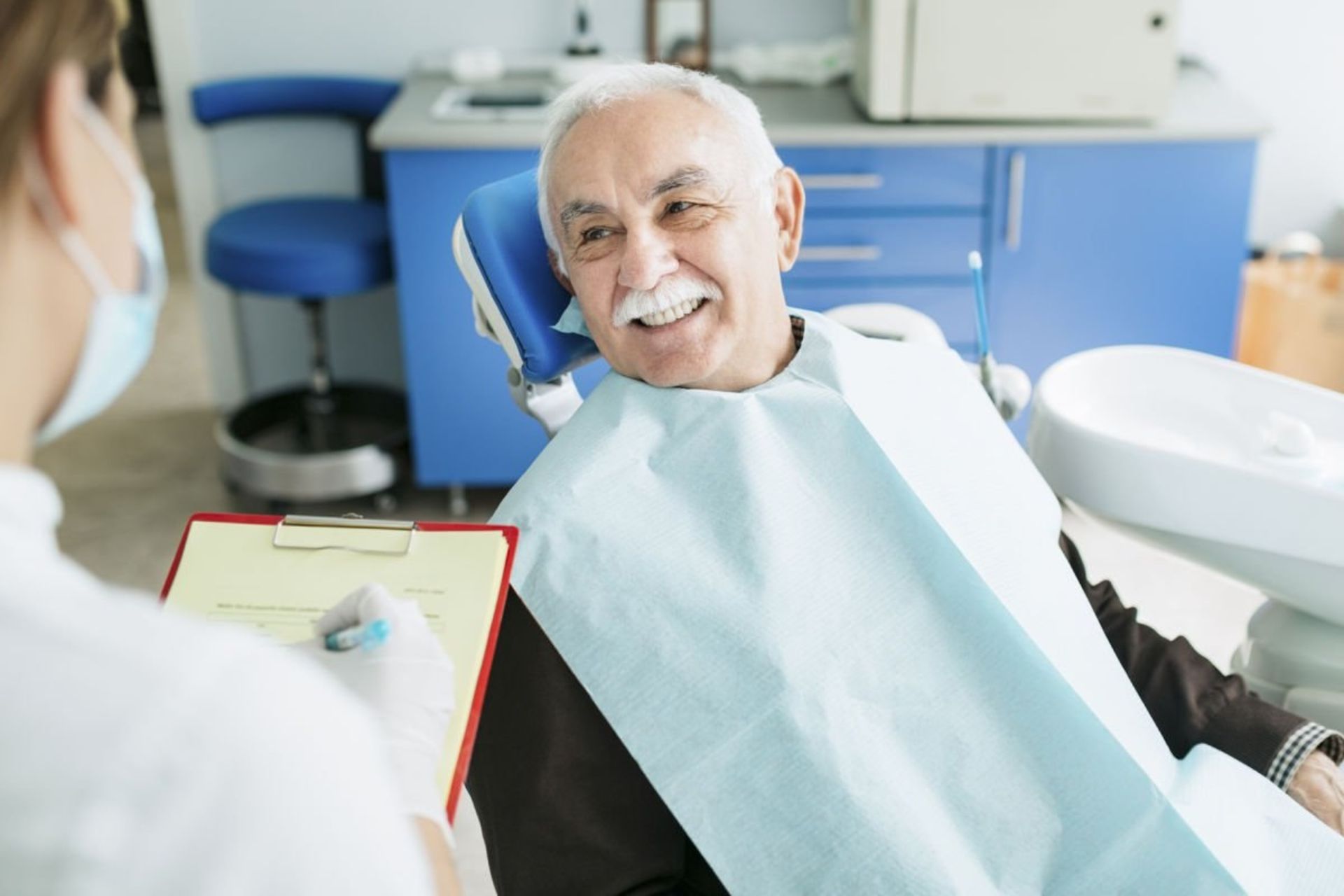 دندان‌پزشک درحال ویزیت پیرمرد است