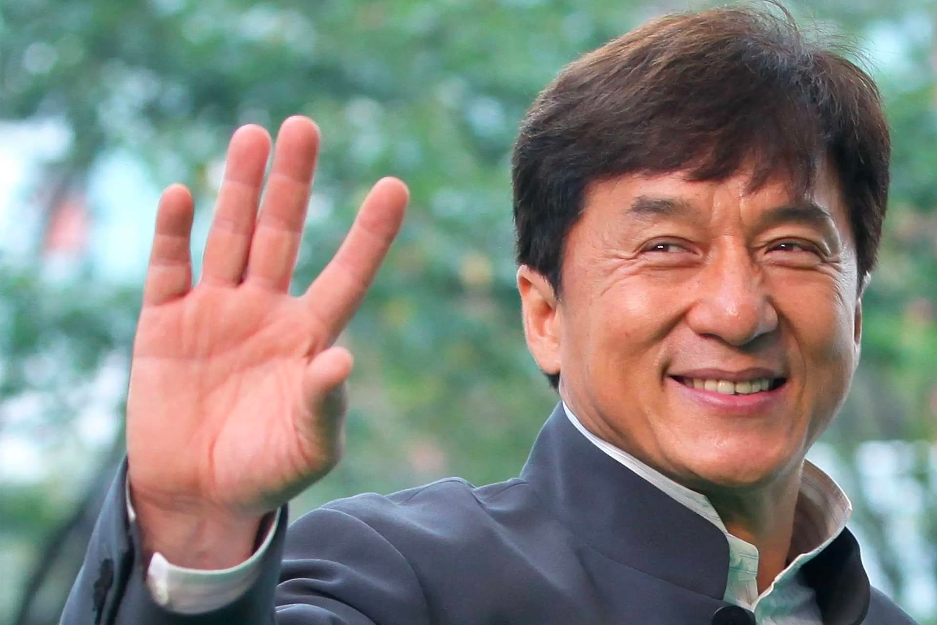 jackie chan waving hand smile 65492a937c0c309f94431345