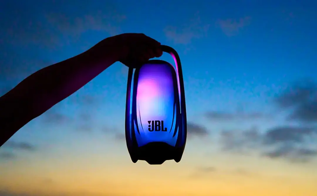 اسپیکر JBL Pulse 6 با نورپردازی رنگی در مقابل آسمان هنگام غروب