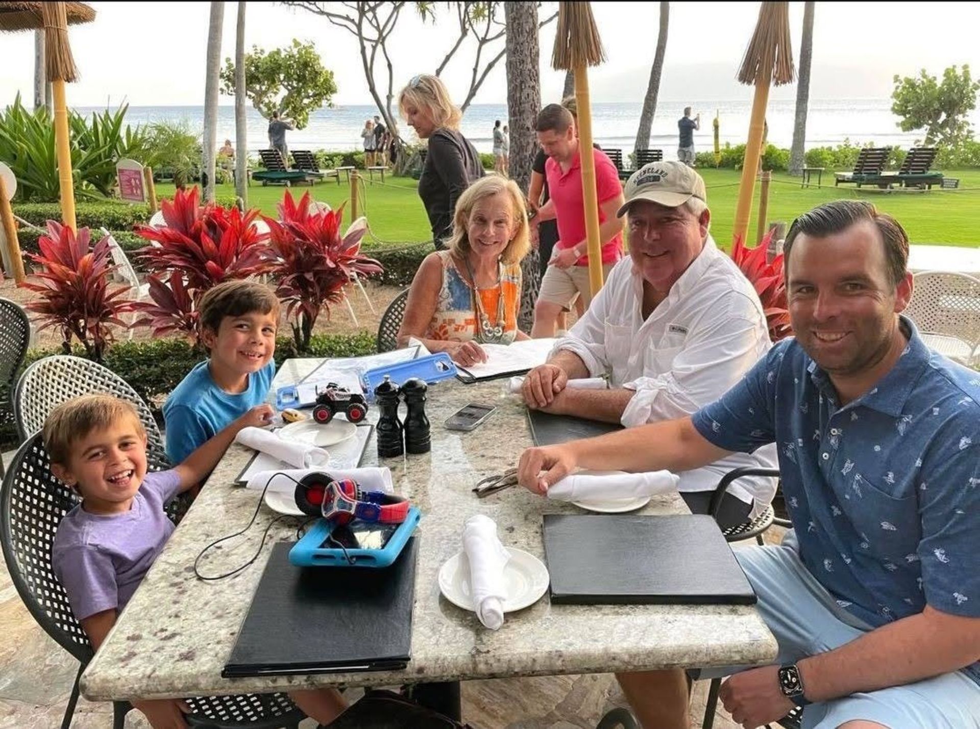 یک مرد مسن در میان خانواده‌اش کنار میز