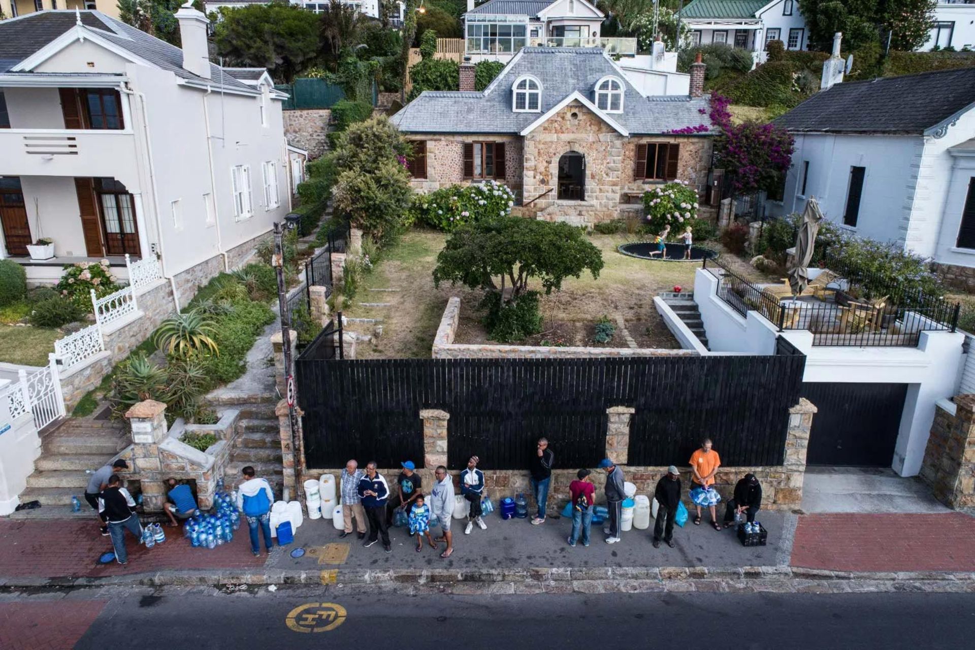 مردم در حاشیه خیابان دبه به دست درانتظار دریافت آب هستند