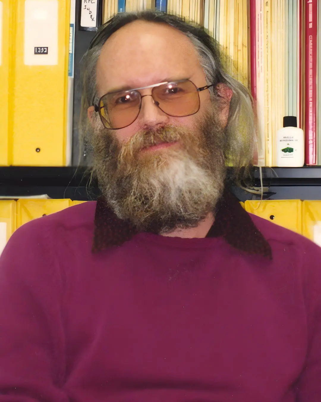 جان پاستل (Jon Postel) با ریش بلند در مقابل قفسه کتاب