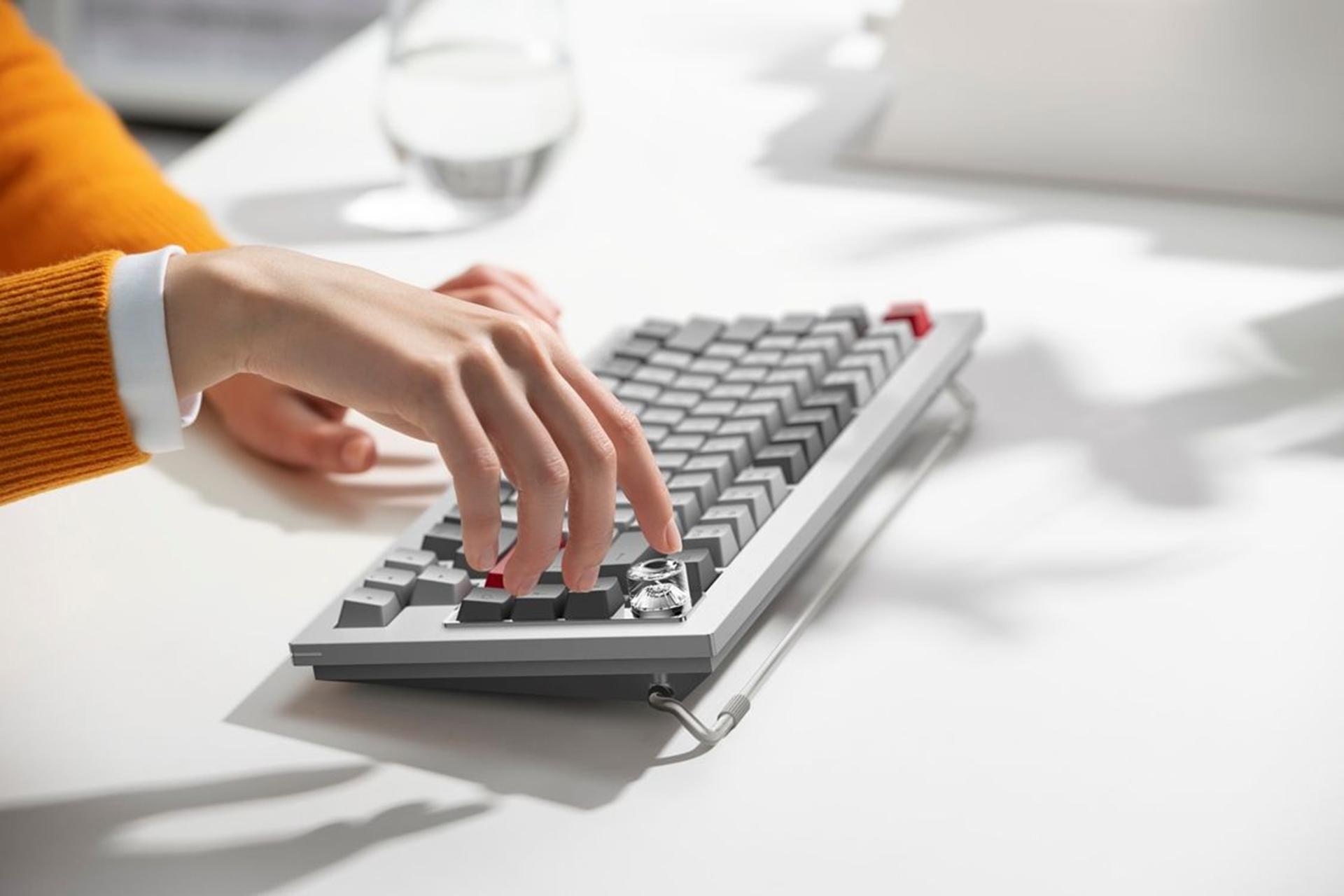 فردی با لباس نارنجی در حال لمس کردن کیبورد OnePlus Featuring Keyboard 81 Pro