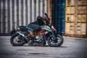 موتورسیکلت کی تی ام KTM Duke 250 2023 نمای جانبی و با موتورسوار در حال پیچیدن