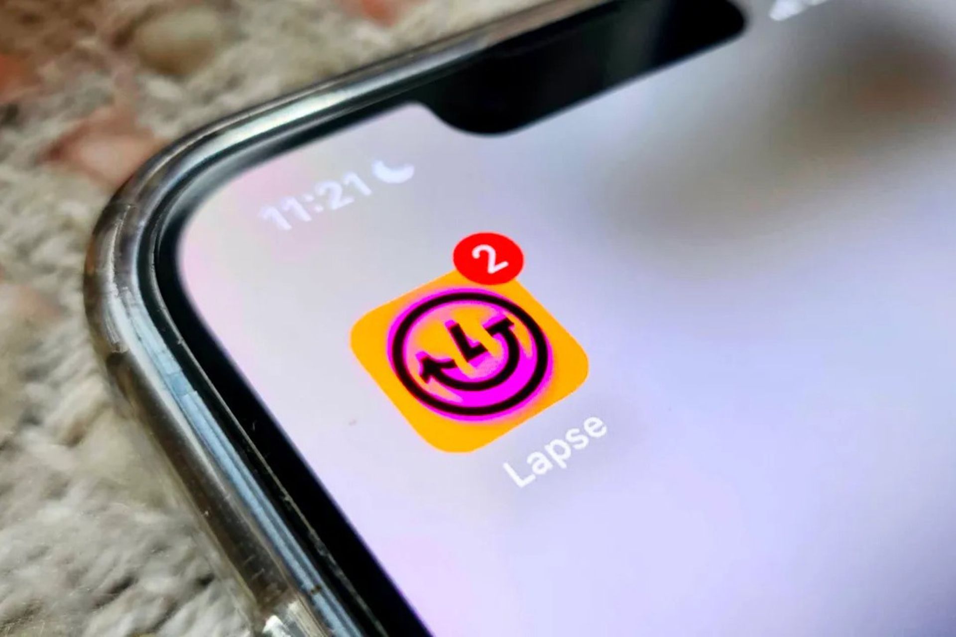 لوگوی اپلیکیشن lapse روی صفحه روشن یک گوشی با دو نوتیفیکیشن