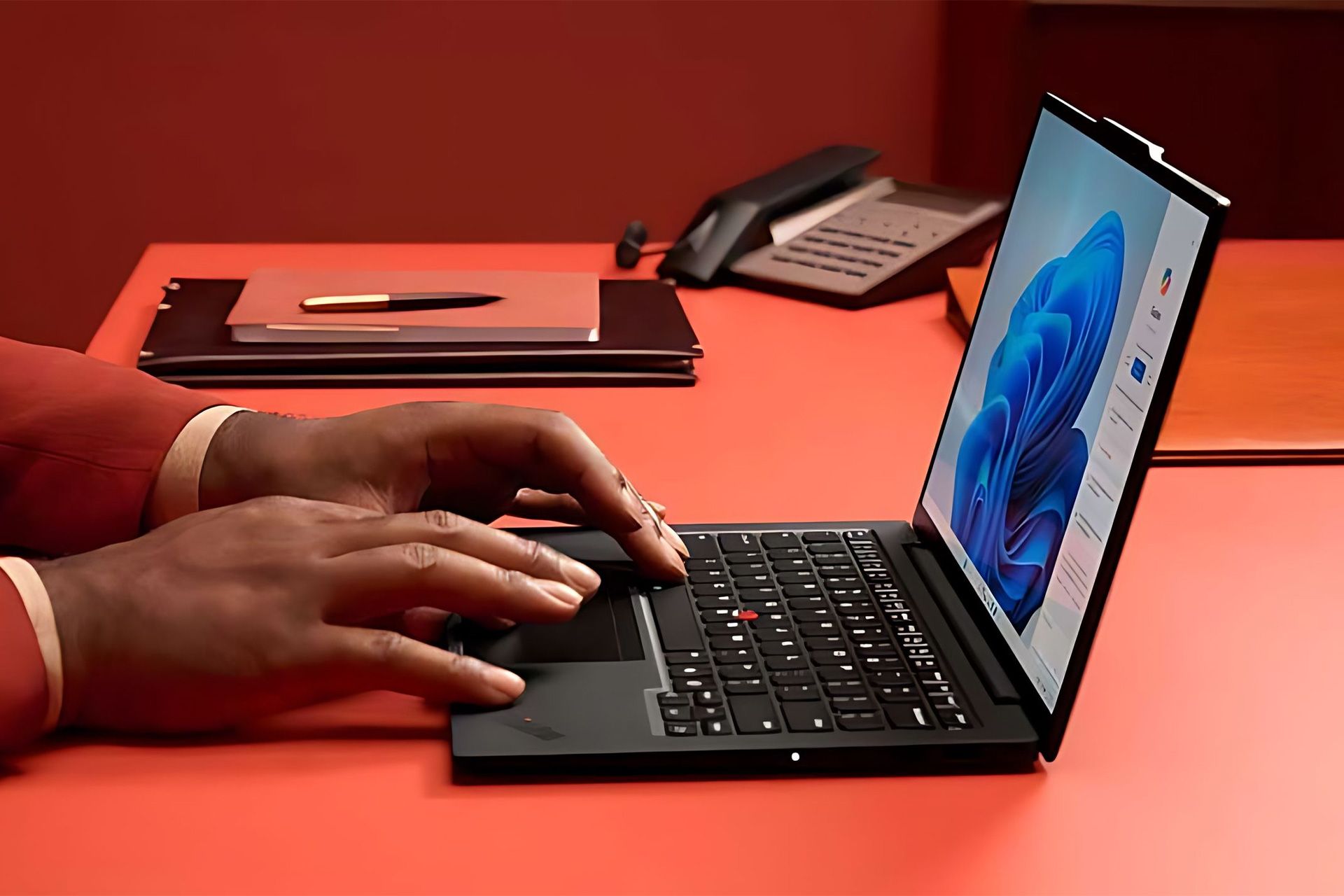 شخصی درحال کار با لپ‌تاپ لنوو ThinkPad روی میز