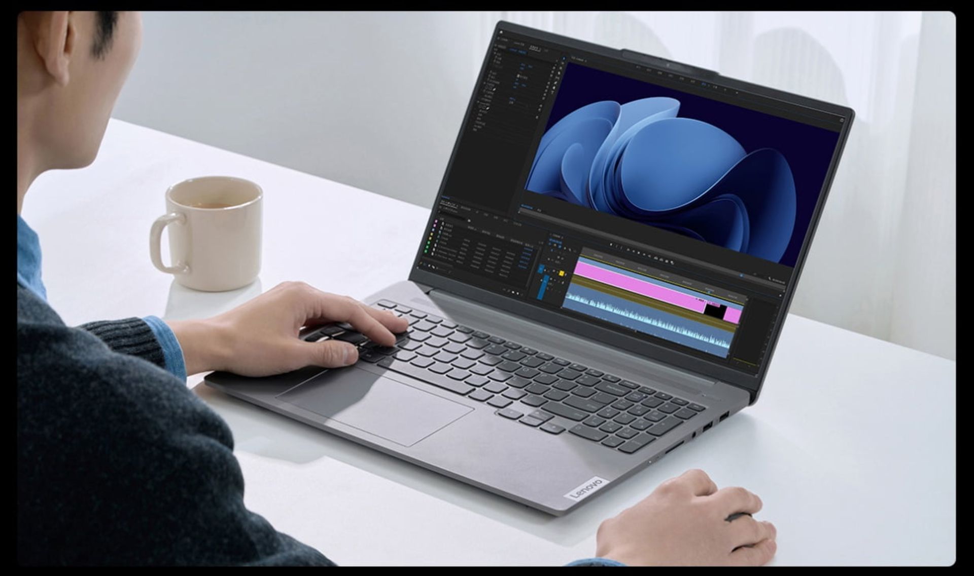 اولترا بوک لنوو Xiaoxim Pro ai 2024  روی میز و مردی درحال تدوین ویدیو با آن 