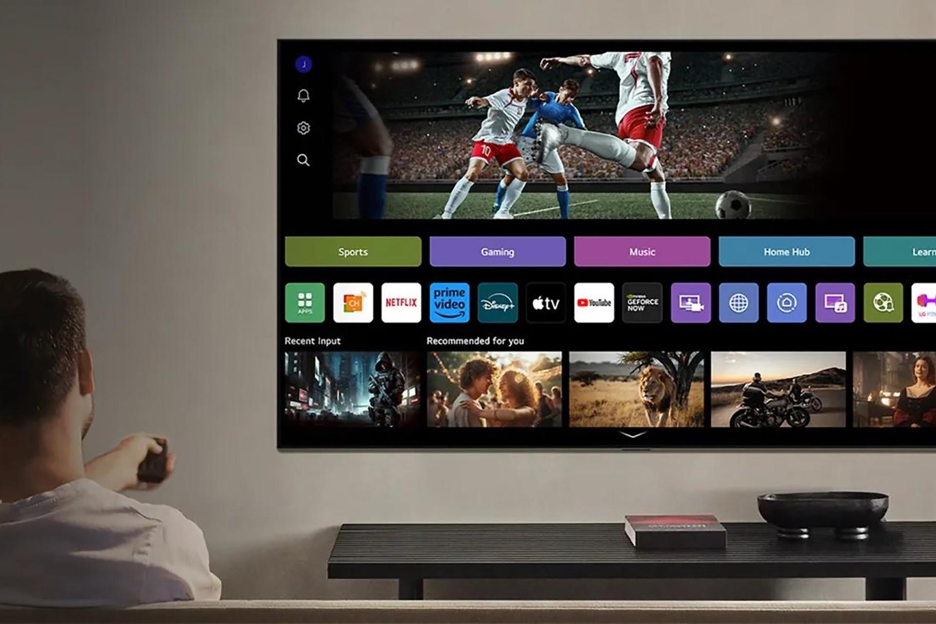 شخصی نشسته جلو تلویزیون میکرو RGB ال‌جی 