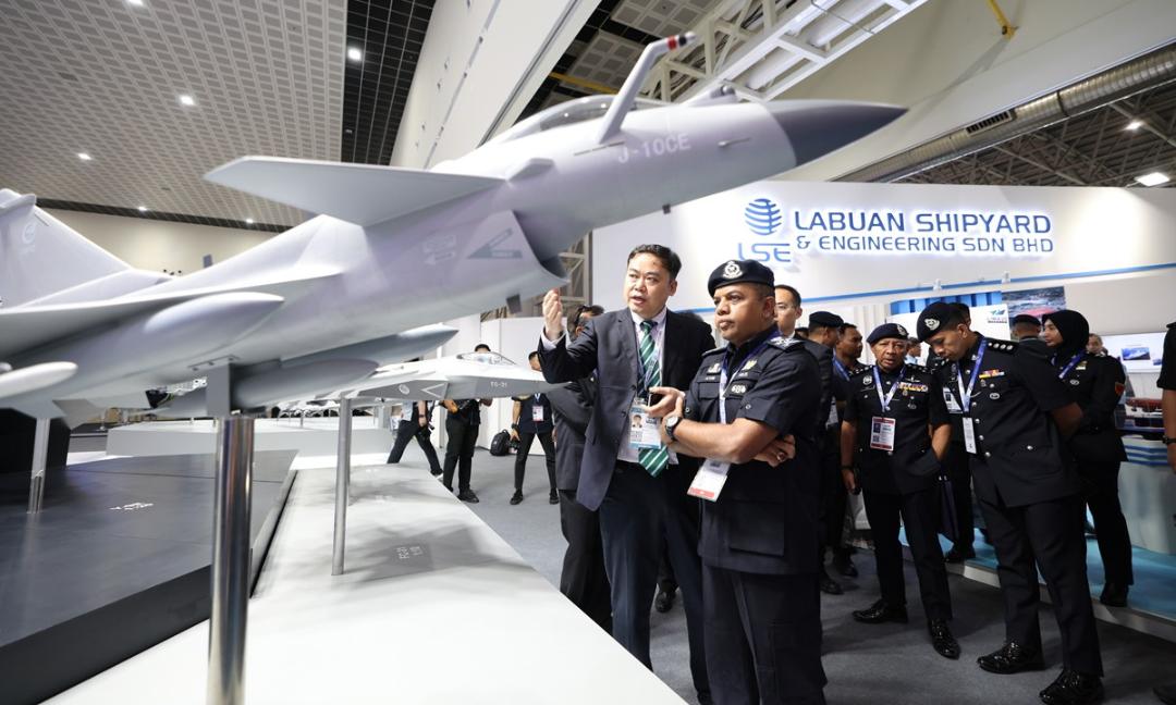بازدیدکنندگان نمایشگاه LIMA 2025 در حال تماشای ماکتی از جنگنده J-10CE چین