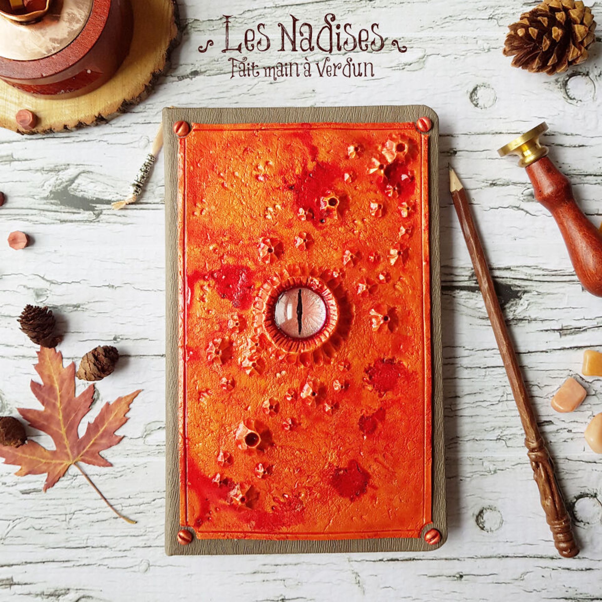 دفتر نارنجی با چشم اژدها مداد چوبدستی جادویی