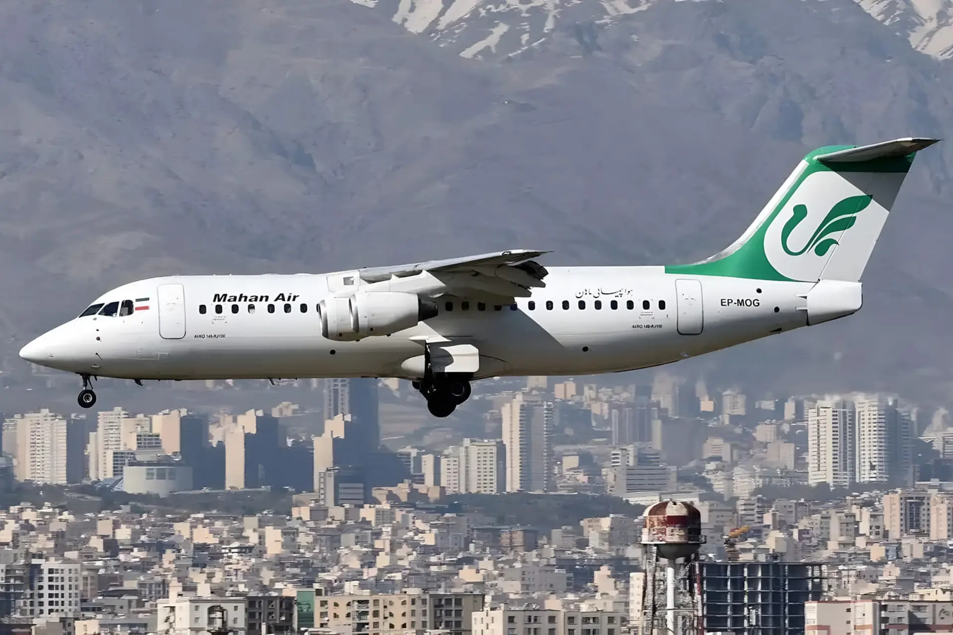 هواپیمای ماهان ایر (Mahan Air) در حال پرواز بر فراز ساختمان‌های شهری