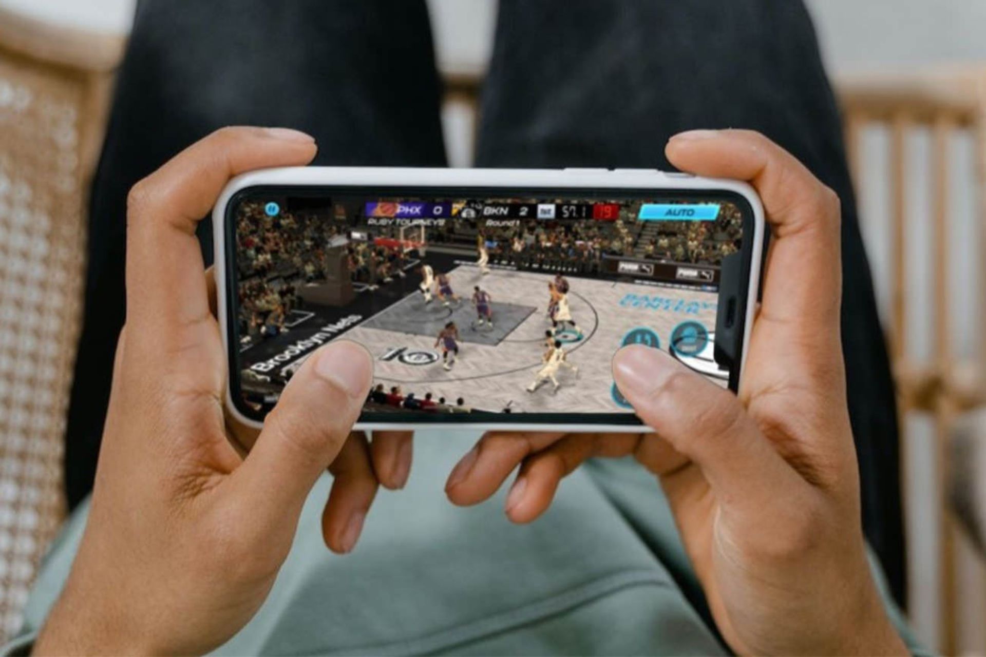 مرد در حال انجام بازی بسکتبال در گوشی