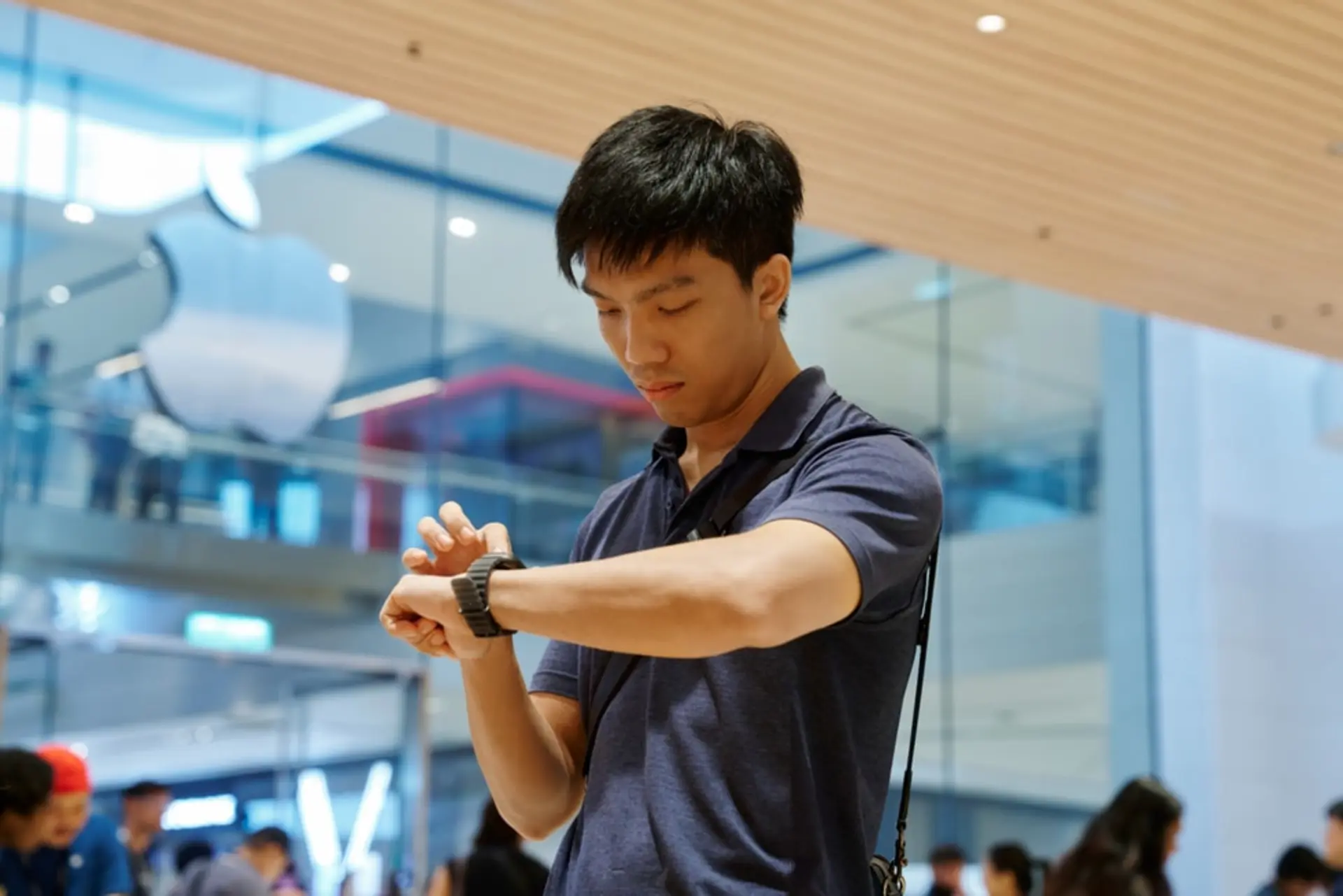 مردی در حال تنظیم و استفاده از اپل واچ (Apple Watch) در فروشگاه محصولات اپل