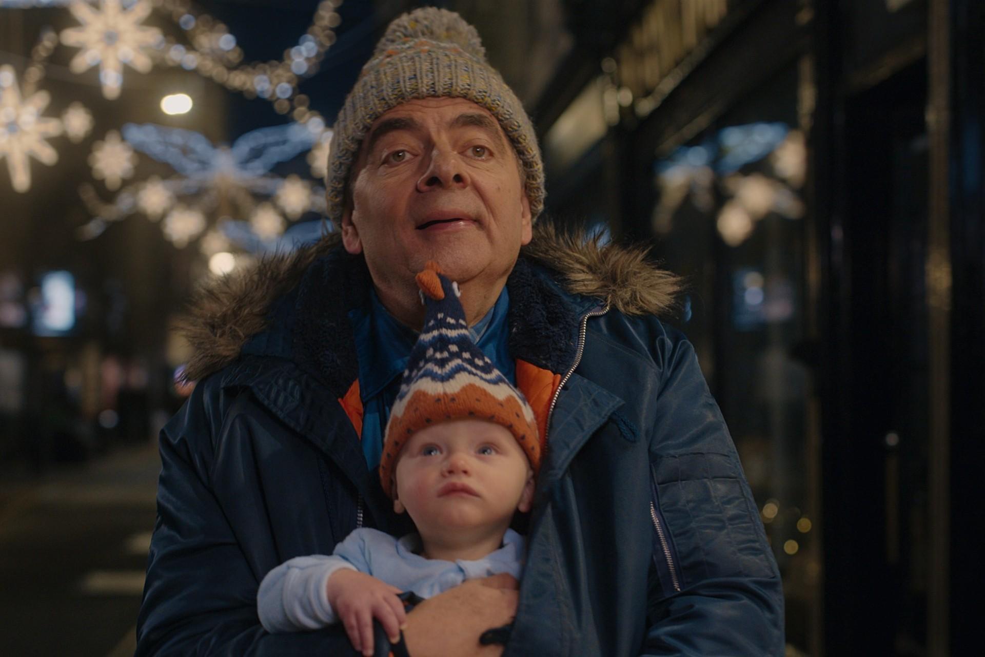 یک مرد با یک نوزاد در آغوش در لباس زمستانی