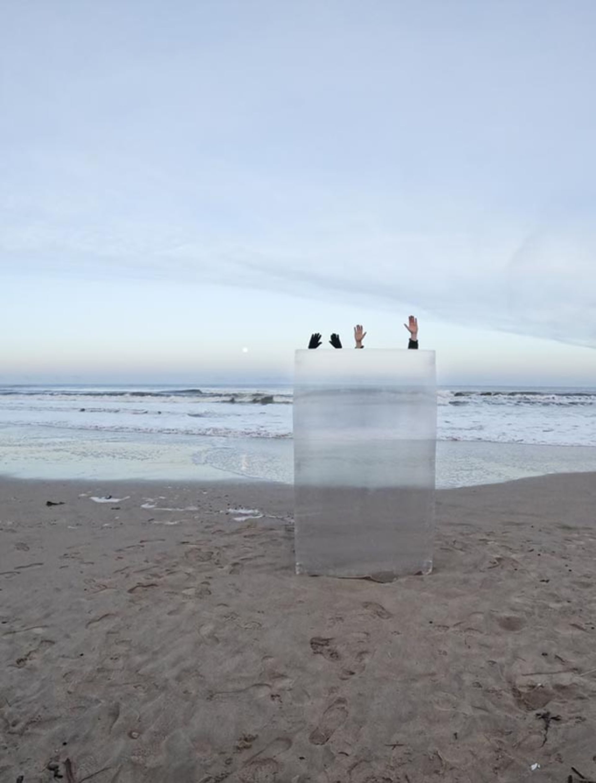 مردی و زنی در ساحل پشت محافظ نامرئی‌کننده قایم شده اند