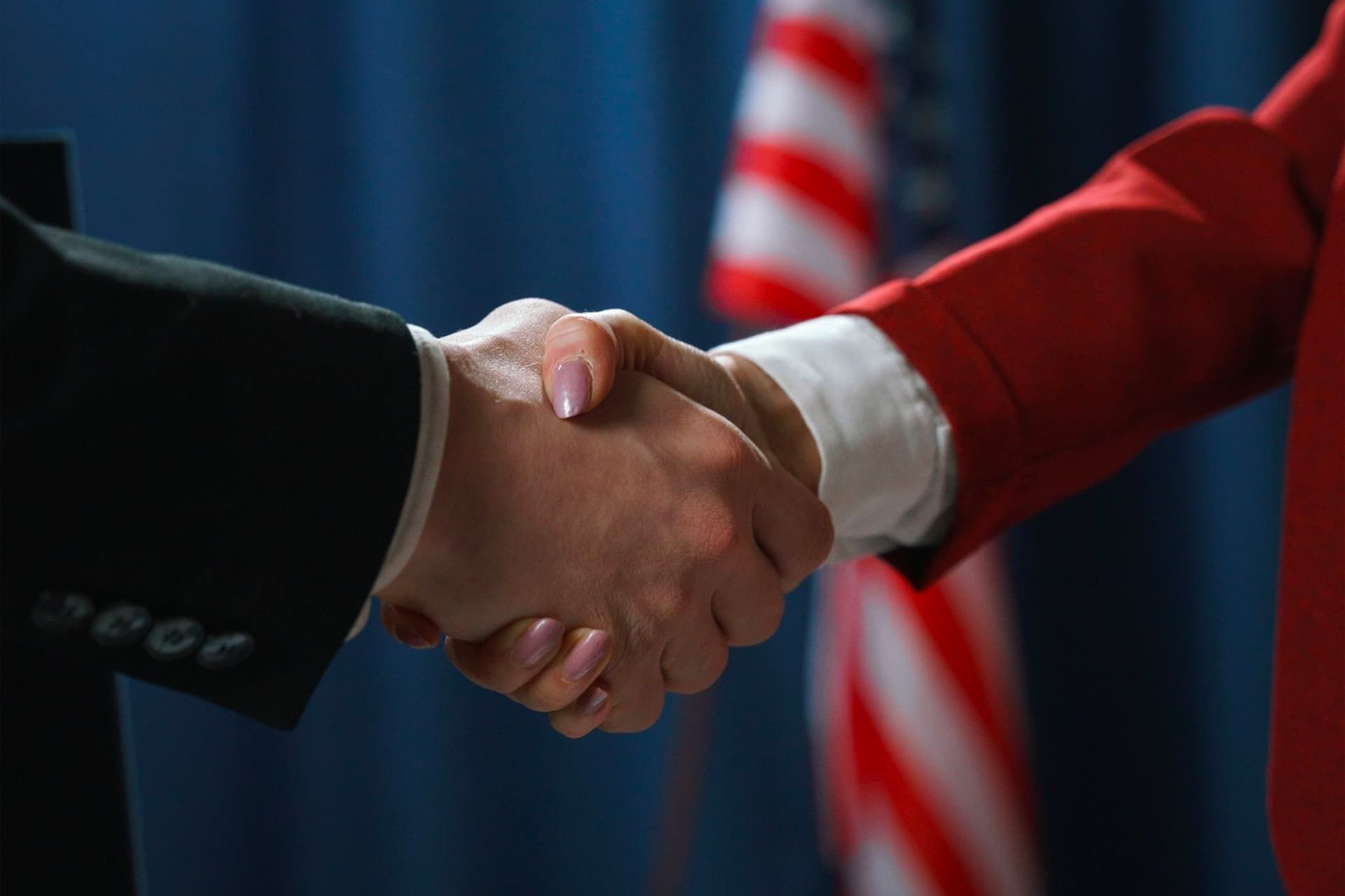 دست دادن زن و مرد با پس زمینه پرچم آمریکا