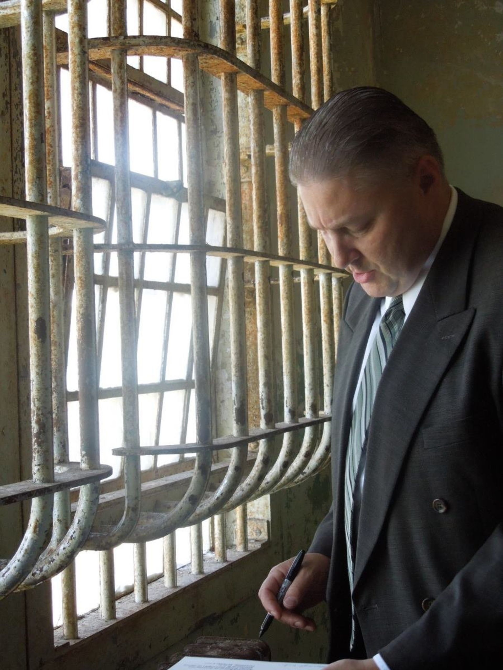 مارشال مایکل دایک مامور پرونده فرار آلکاتراز- مردی کنار نرده پنجره خیره به کاغذ