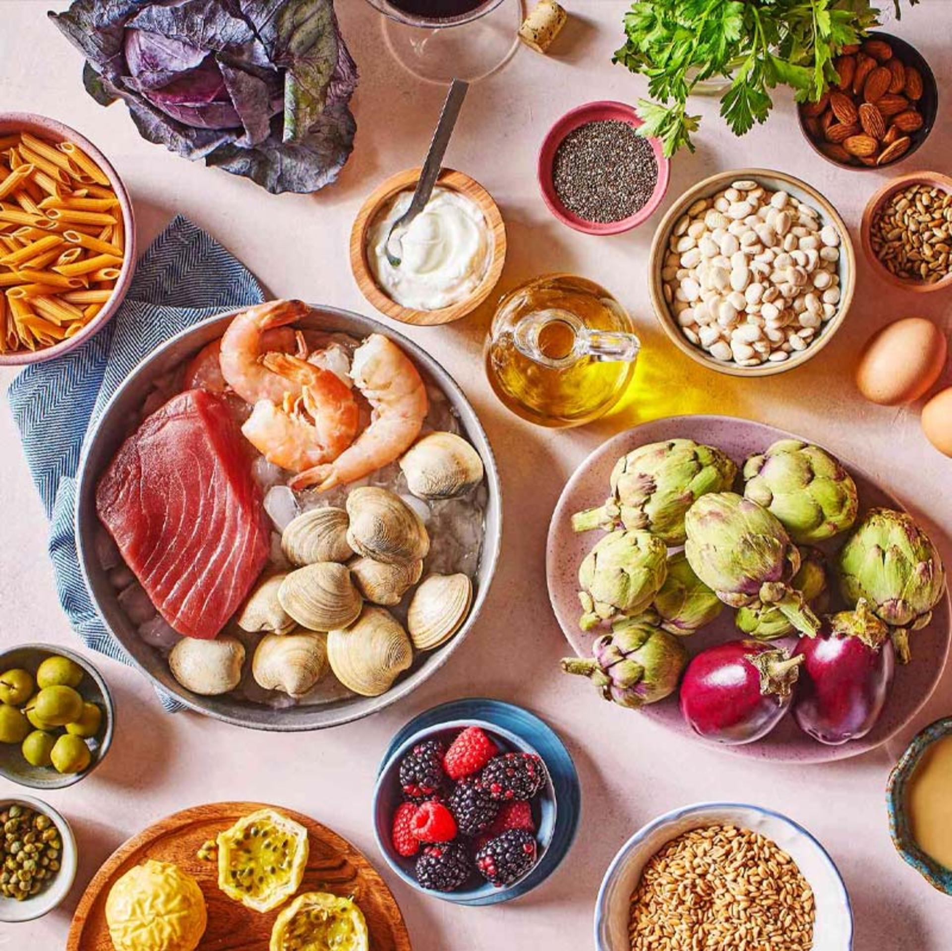 مواد غذایی رژیم مدیترانه‌ای روی میز صورتی