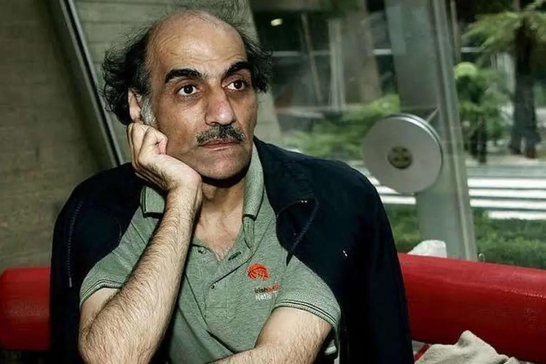 یک مرد میان‌سال با دست زیر چانه