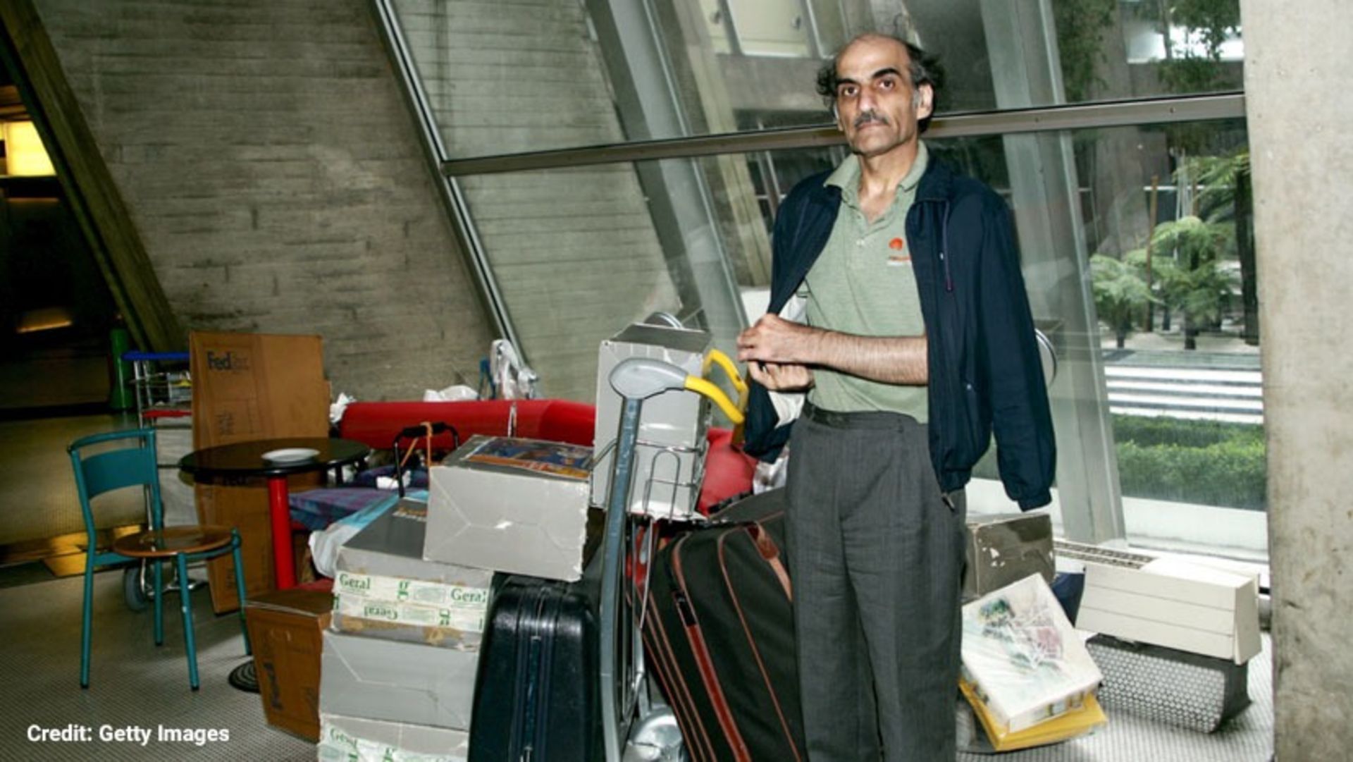 یک مرد میان‌سال در کنار وسایلش در فرودگاه