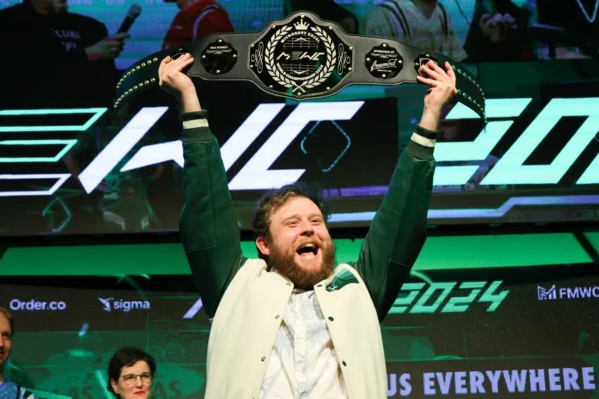 یک پسر جوان در حال بلندکردن کمربرند قهرمانی اکسل