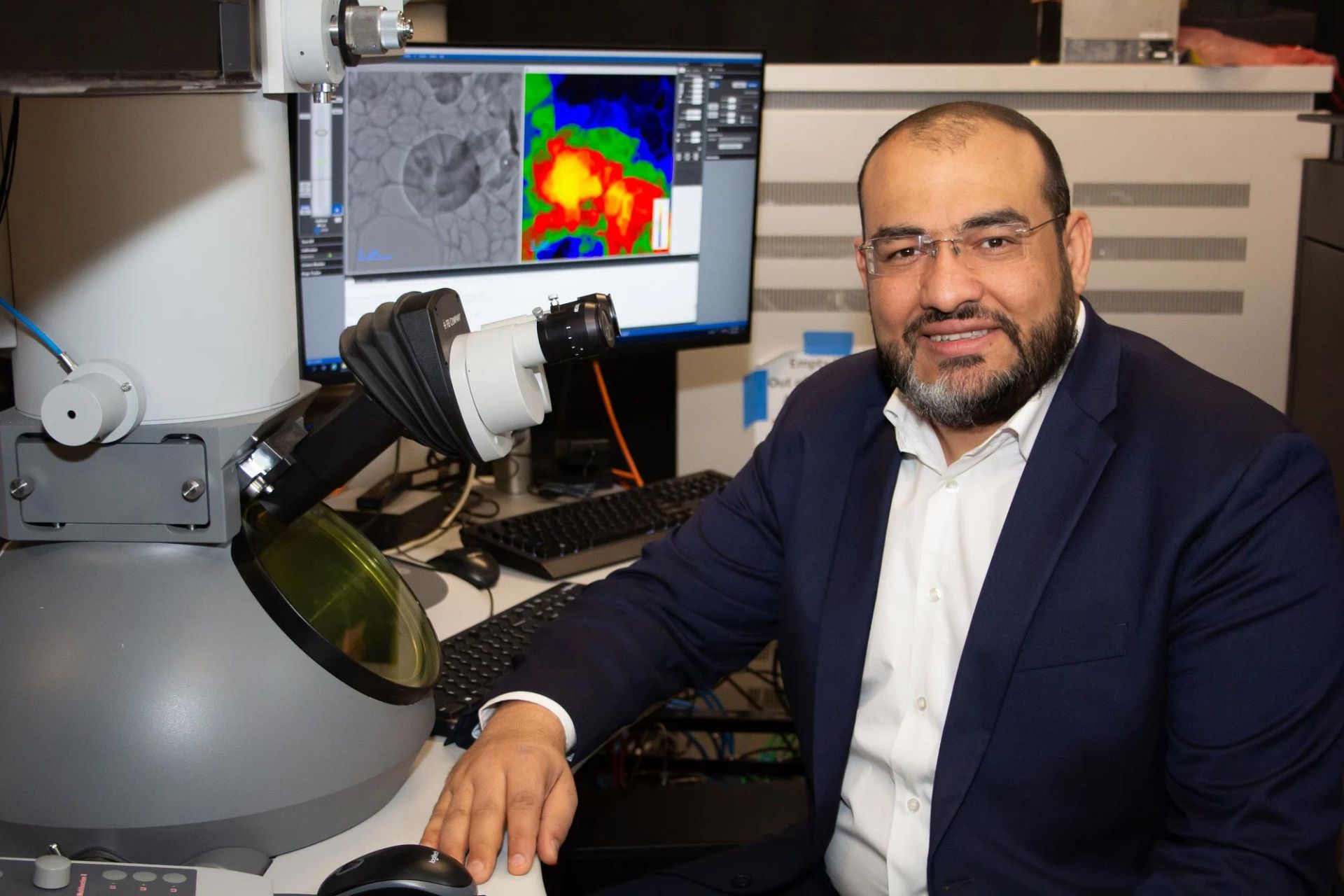 محمد حسن دانشیار فیزیک و علوم نوری پشت میکروسکوپ نشسته است