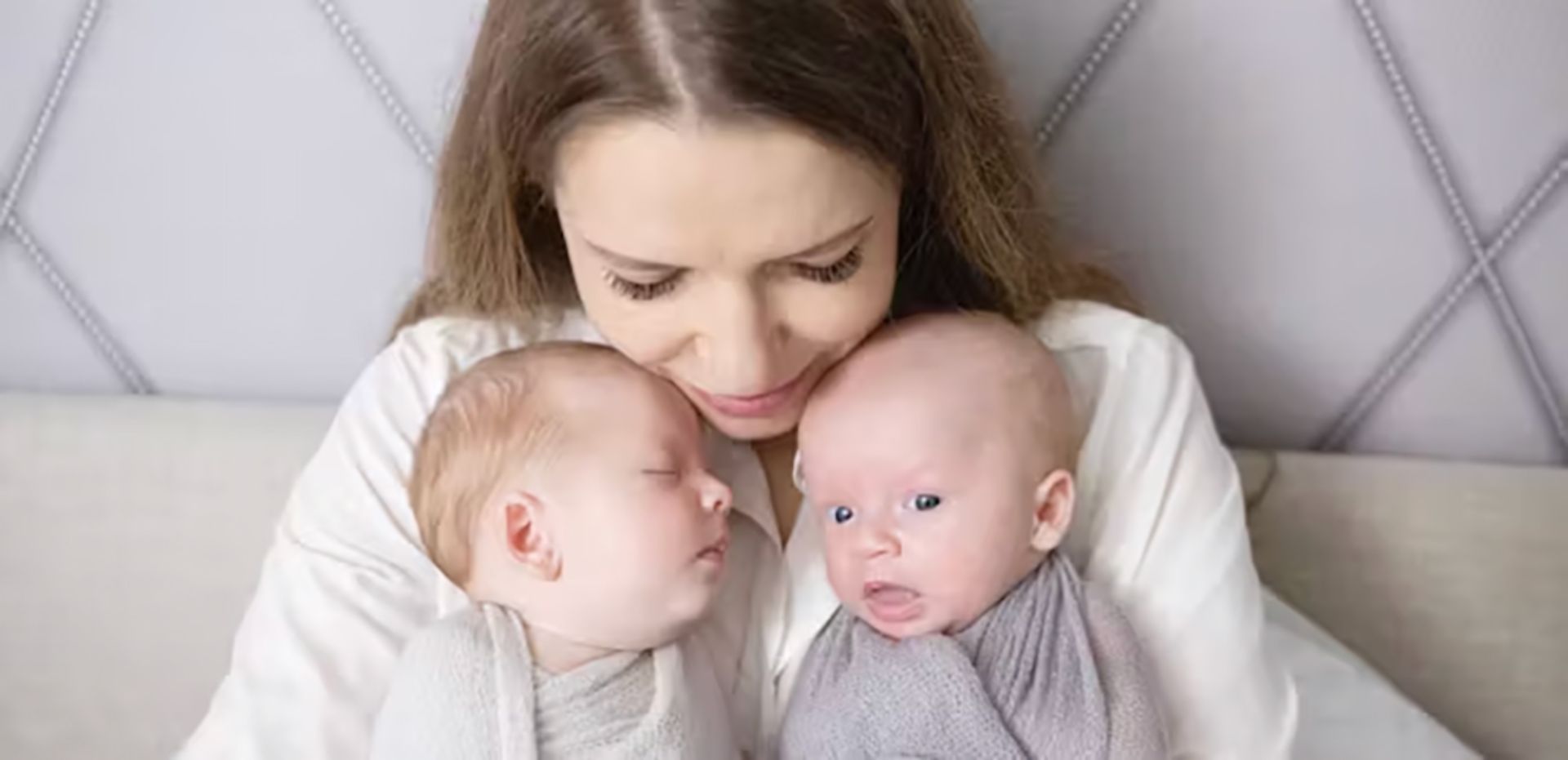 مادری که دو نوزاد دوقلویش را در آغوش گرفته است