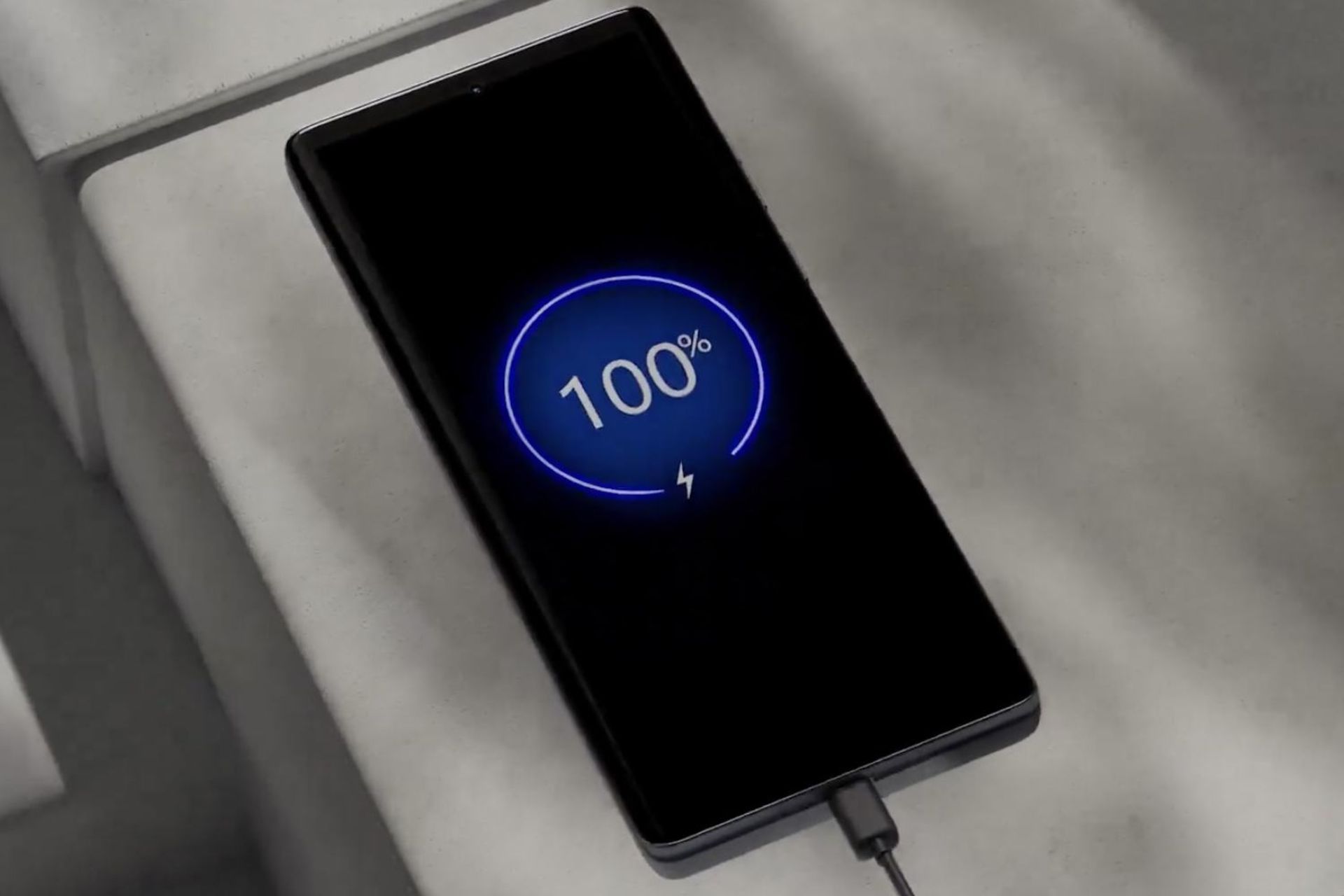 گوشی موتورولا اج ۵۰ فیوژن روی میز درحال شارژ