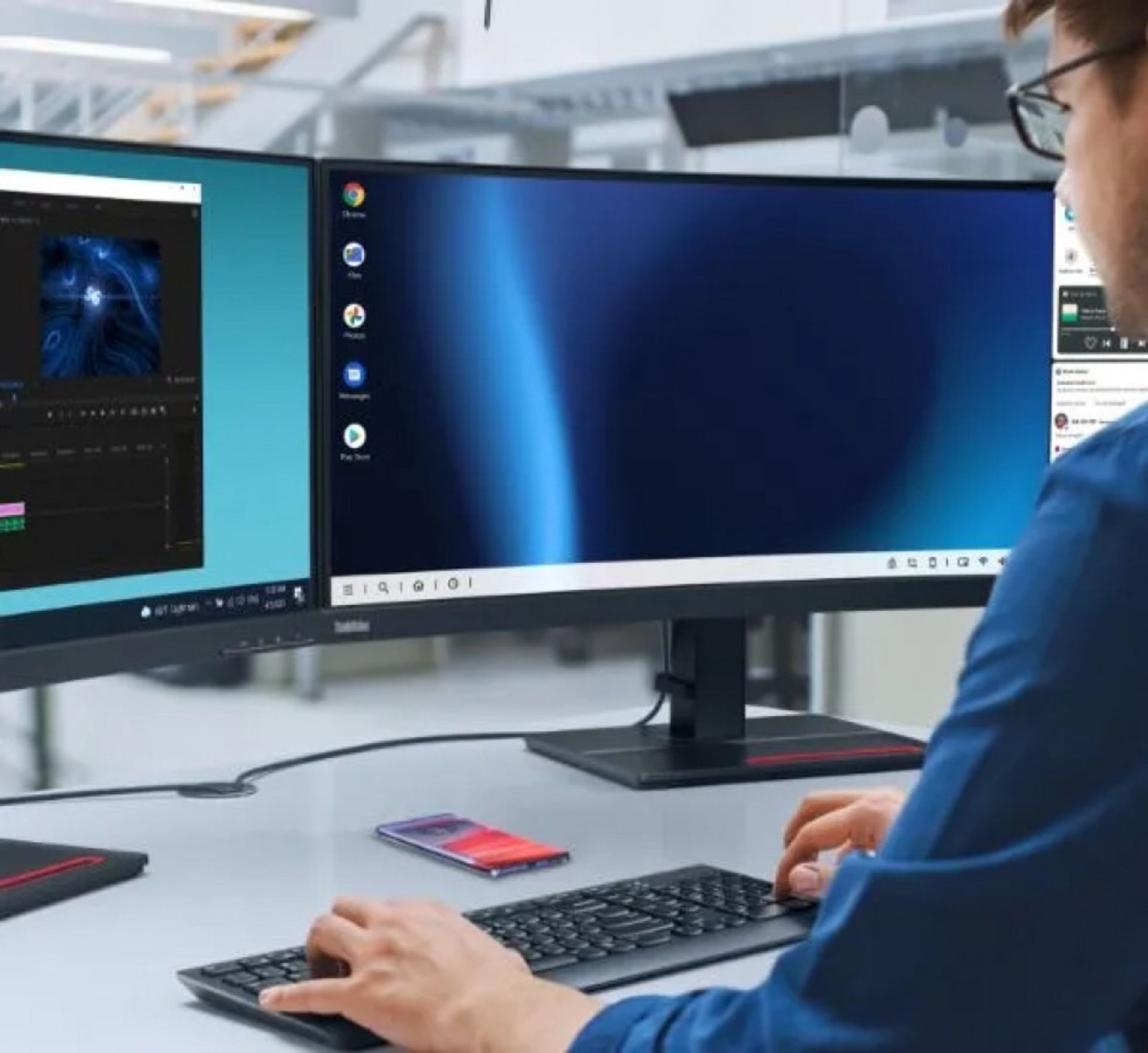 شخصی درحال کار با دسکتاپ و گوشی موتورولا اج ۵۰ پرو روی میز