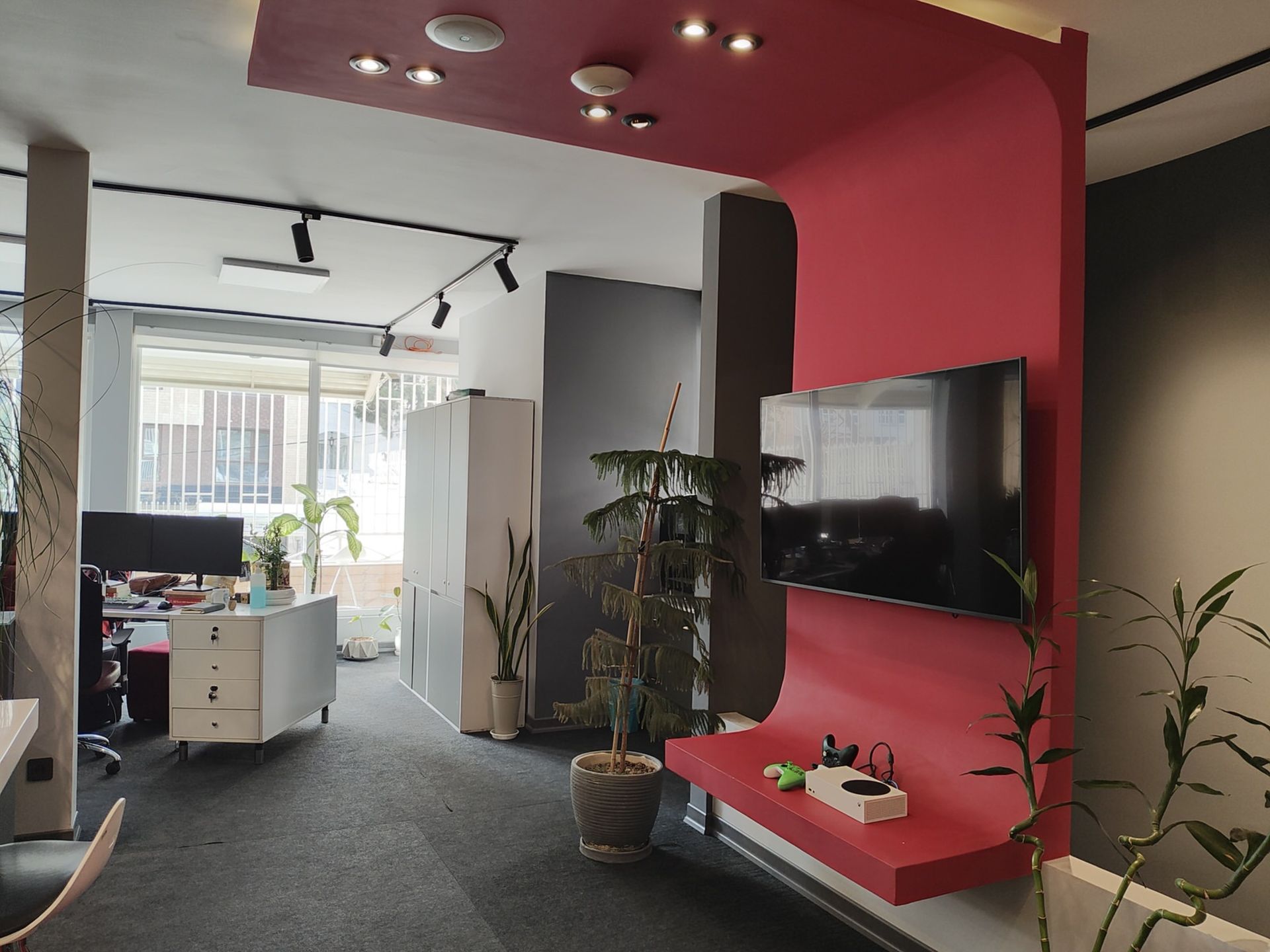 نمونه عکس ریزر ۴۰ اولترا از محیط داخلی یک دفتر کار با یک تلویزیون روی دیوار قرمز رنگ و پنجره روشن رو به حیاط