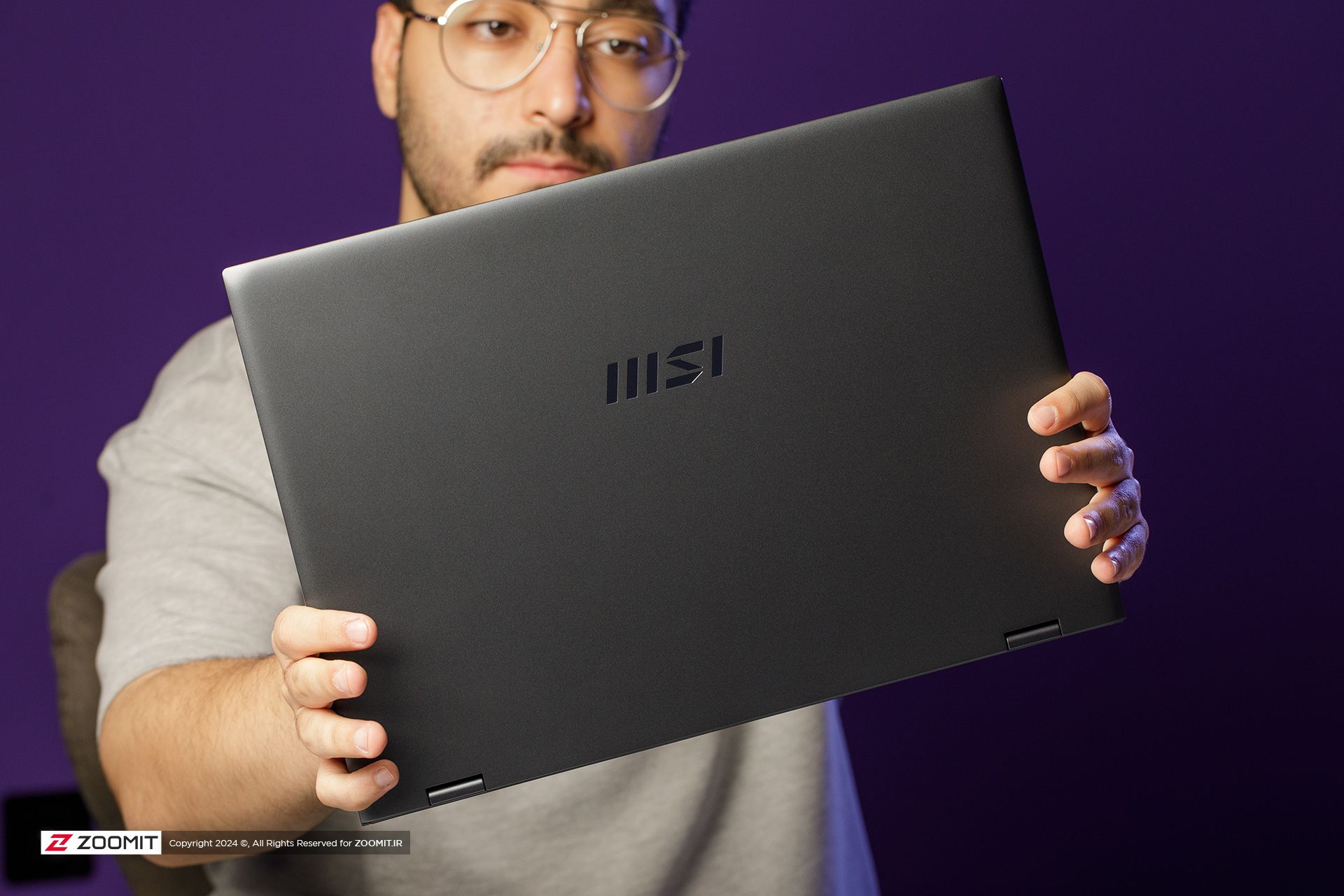 A laptop held in the hands of a boy