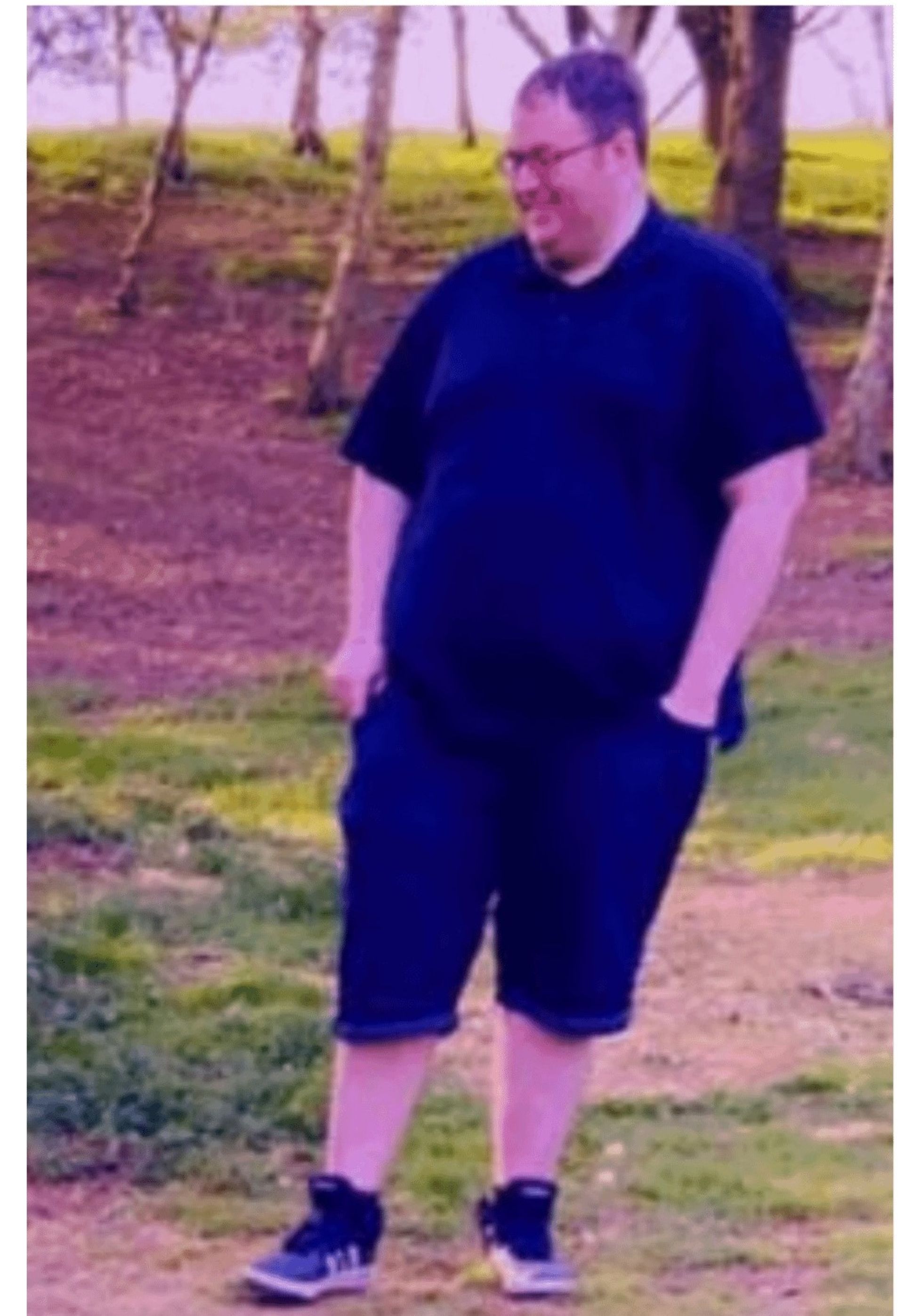 یک مرد جوان با تیشرت مشکی در حال قدم‌زدن در طبیعت