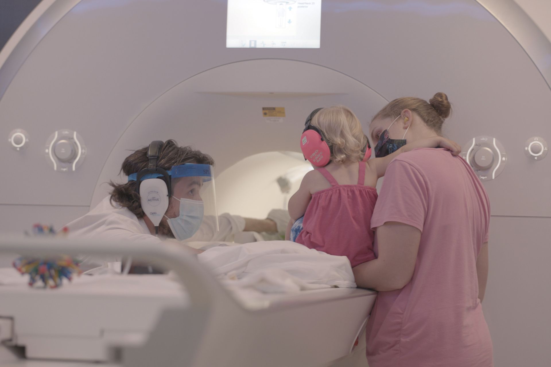 نیک ترک براون، دانشمند دانشگاه ییل (سمت چپ) کودک در آغوش پرستار را برای انجام مطالعه آماده می‌کند