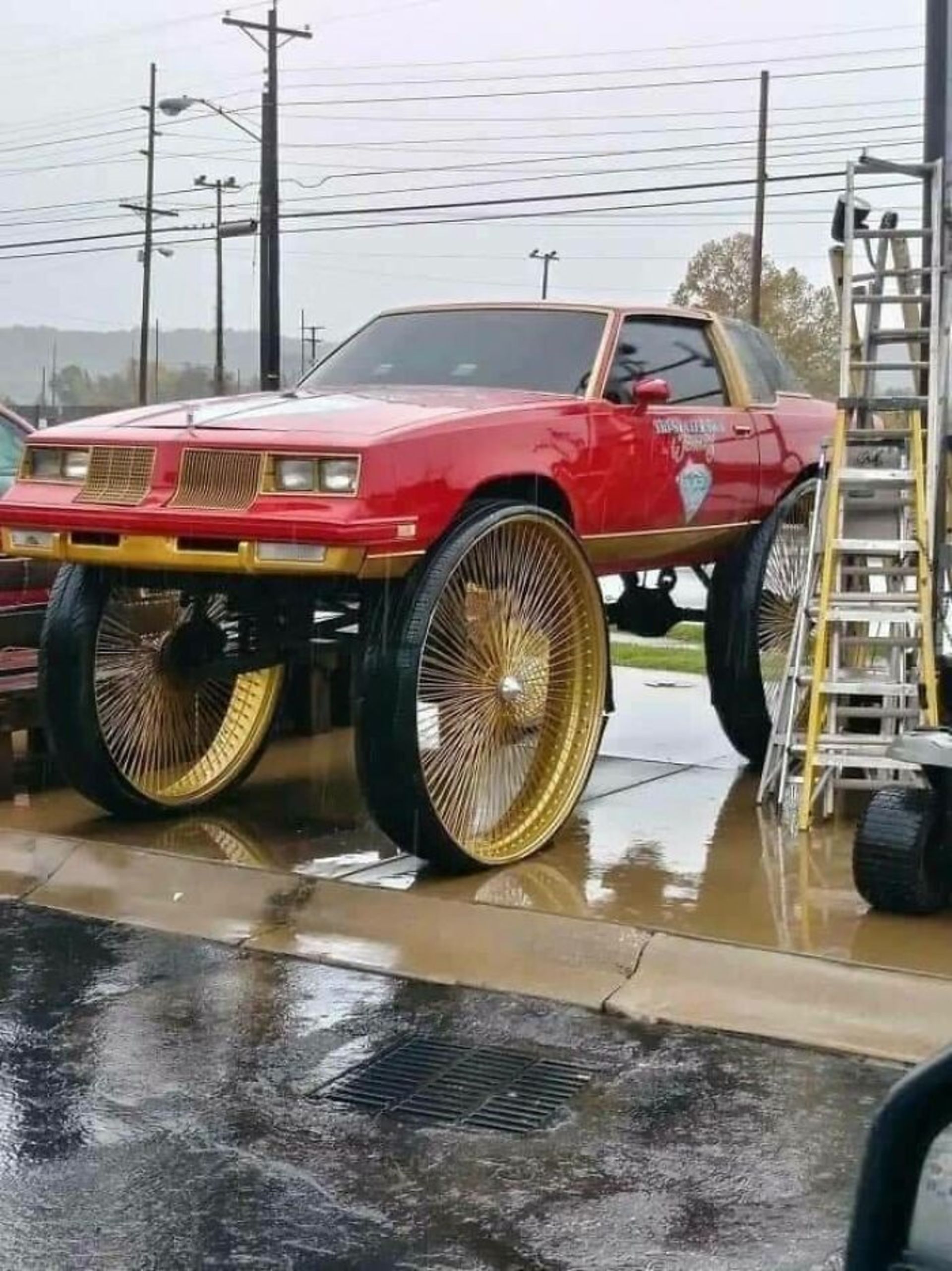 ماشین کلاسیک قرمز با چرخ‌های بسیار بزرگ