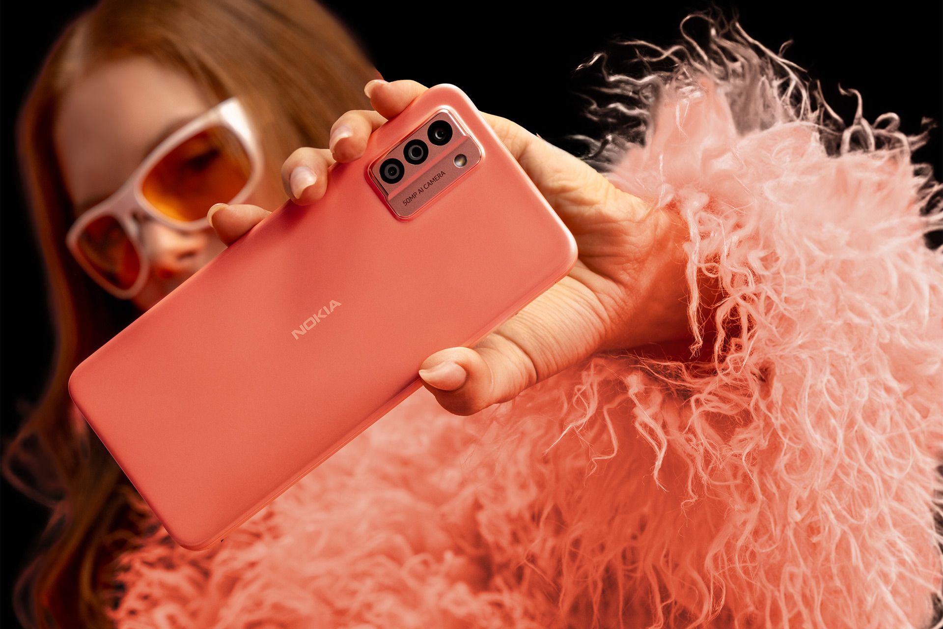 قاب پشتی گوشی نوکیا G22 به رنگ هلویی در دست یک شخص