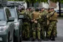 سربازان ارتش نروژ (Norwegian Army) با تجهیزات نظامی در کنار خودروهای نظامی مستقر شده‌اند