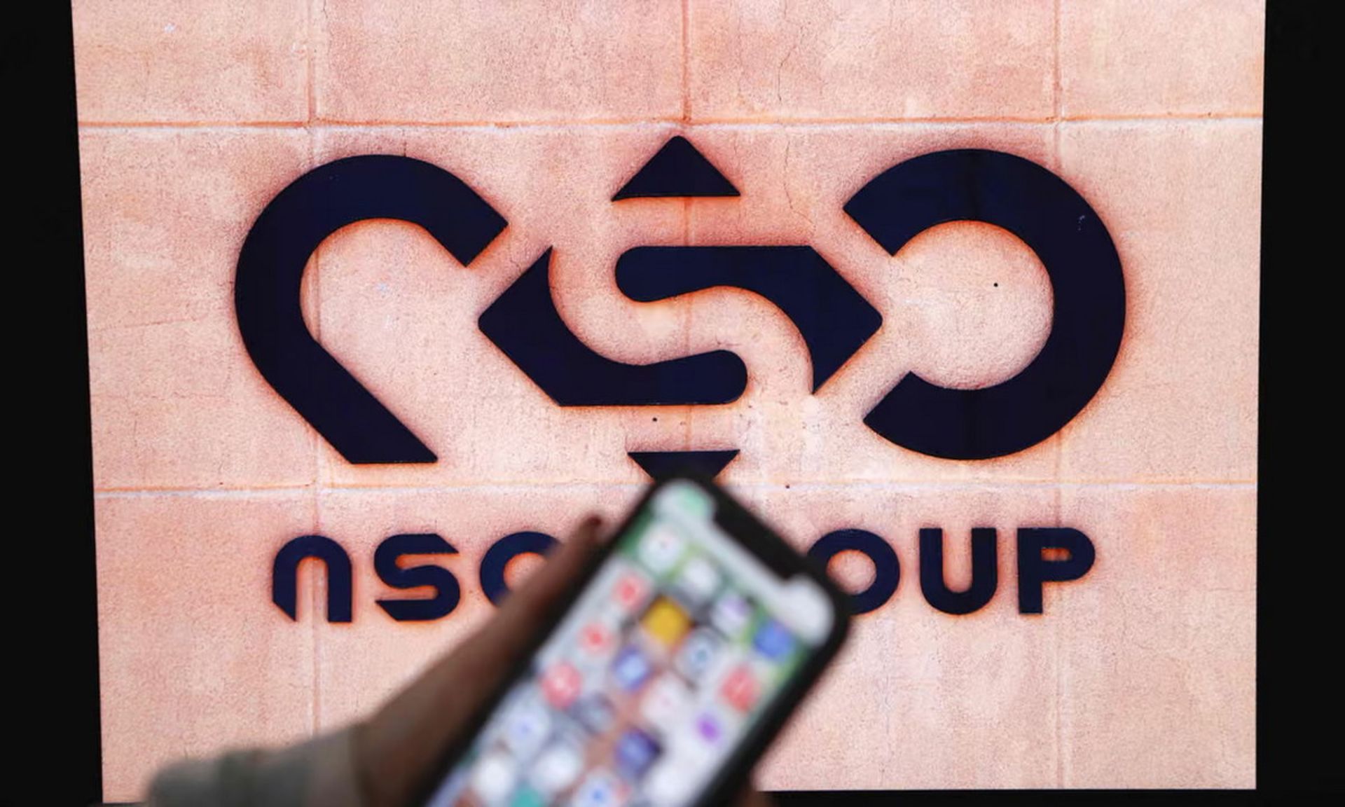 یک گوشی جلوی لوگوی NSO Group 