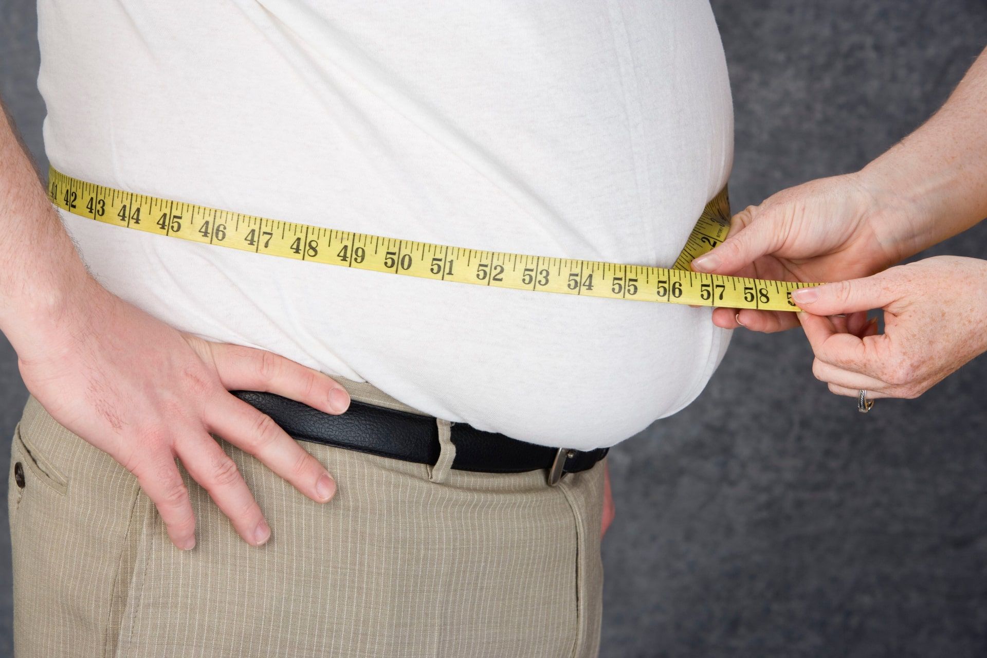 تجمع بیش از حد چربی در بدن و اندازه گیری دور شکم فردی که چاق است