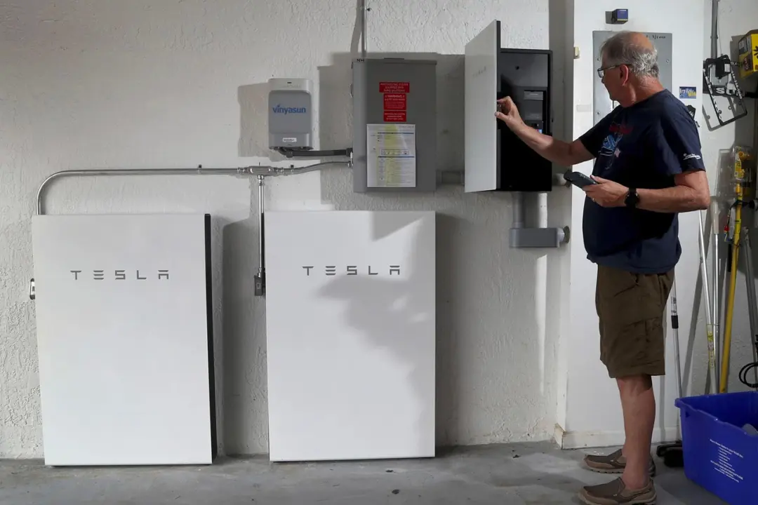 مرد پیر در حال استفاده از شارژر پاوروال / Powerwall تسلا