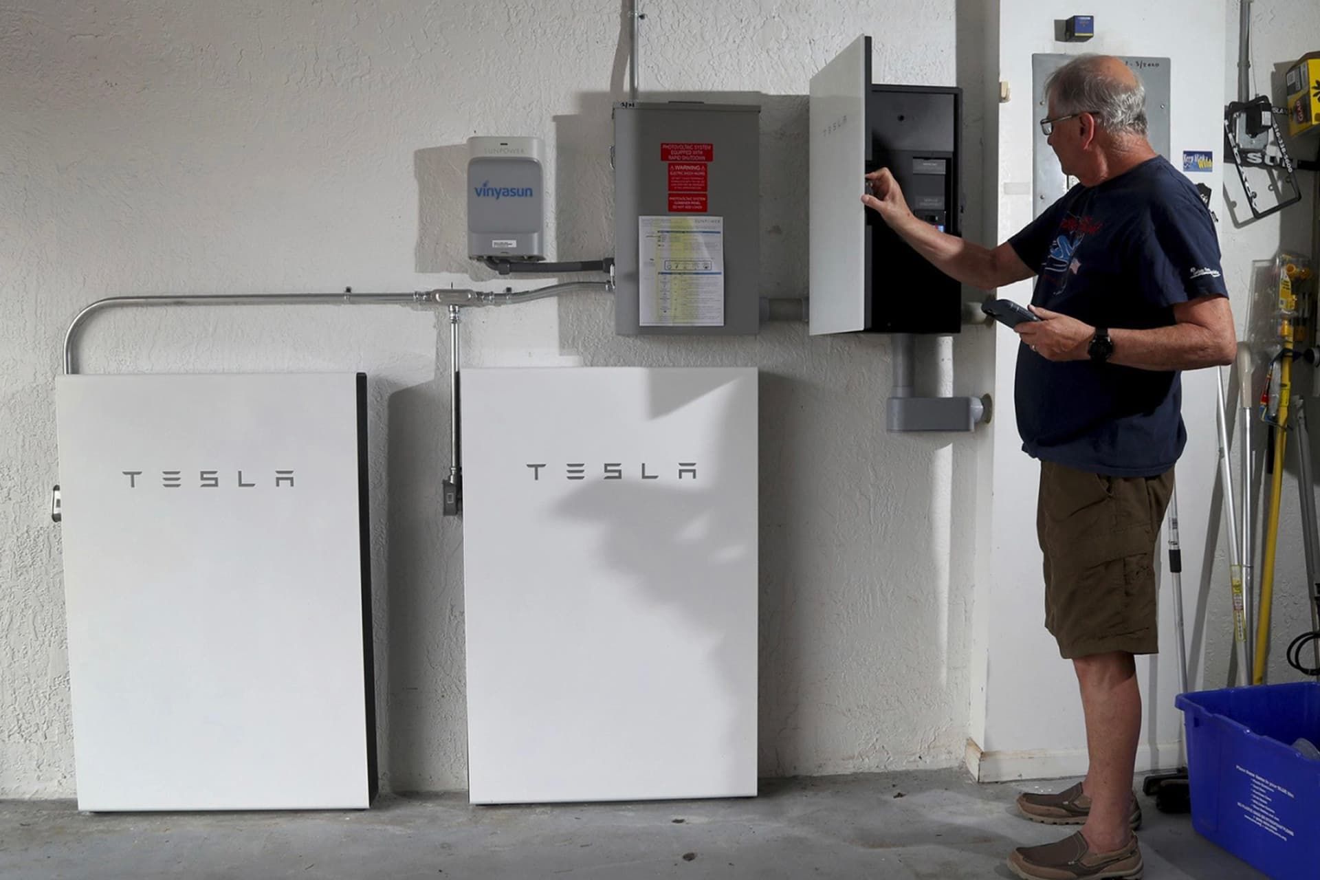 مرد پیر در حال استفاده از شارژر پاوروال / Powerwall تسلا