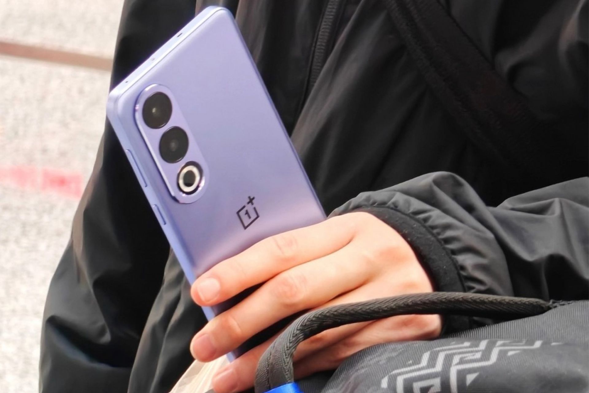 پنل پشتی گوشی وان پلاس ایس 3V در دستان یک شخص از نمای نزدیک رنگ ارغوانی