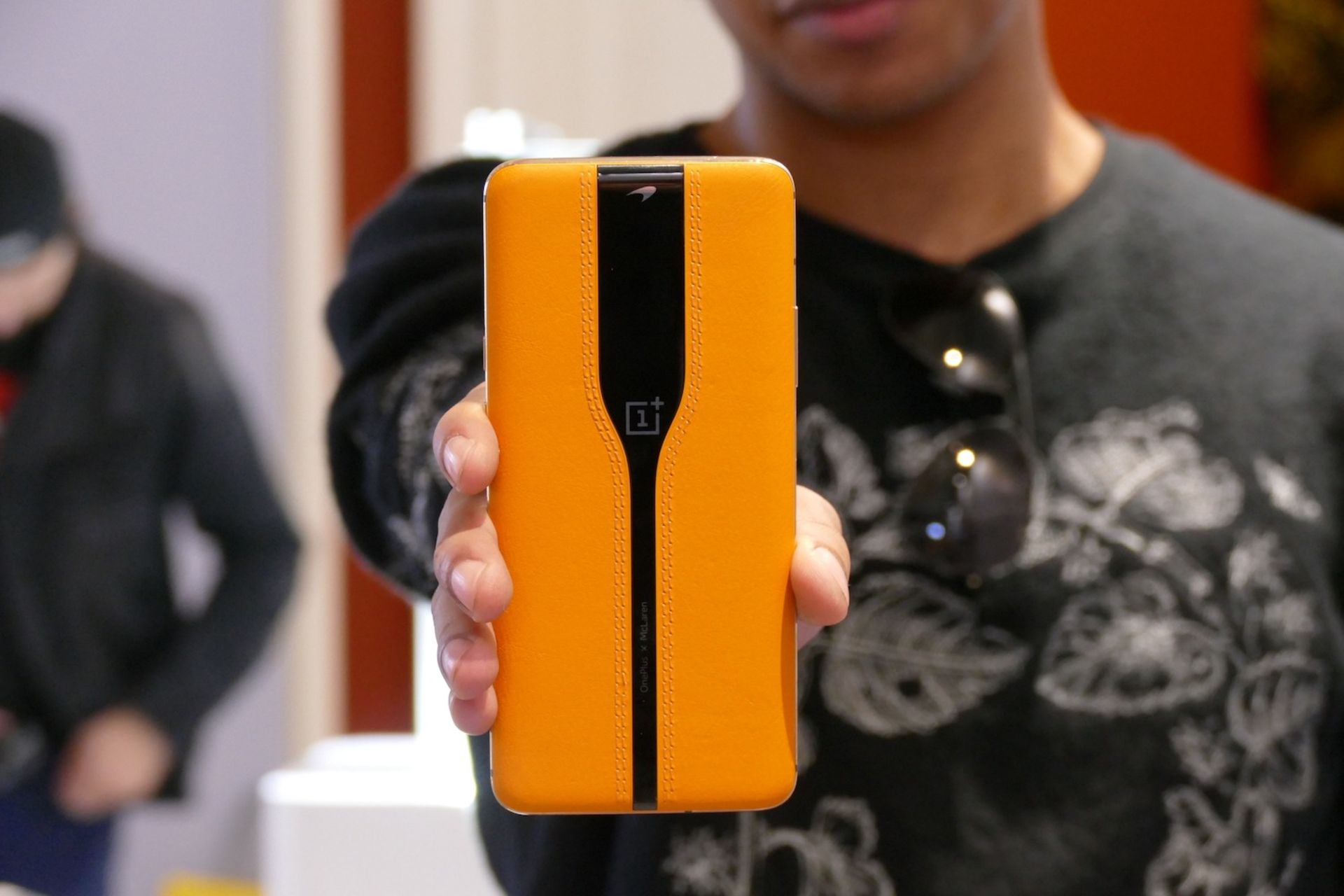 گوشی کانسپت وان‌ پلاس اوپو با قاب زرد رنگ که فردی آن را در دست گرفته