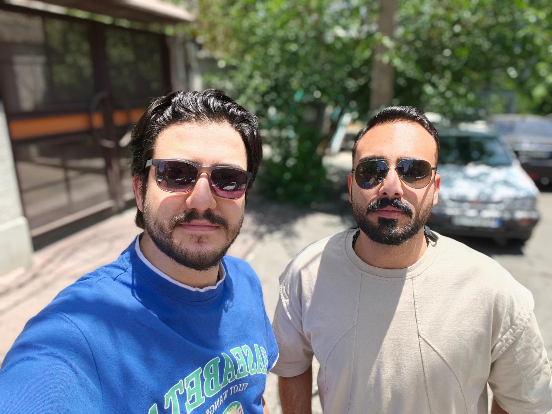 دو مرد در فضای باز در کنار یک خودرو در روز آفتابی