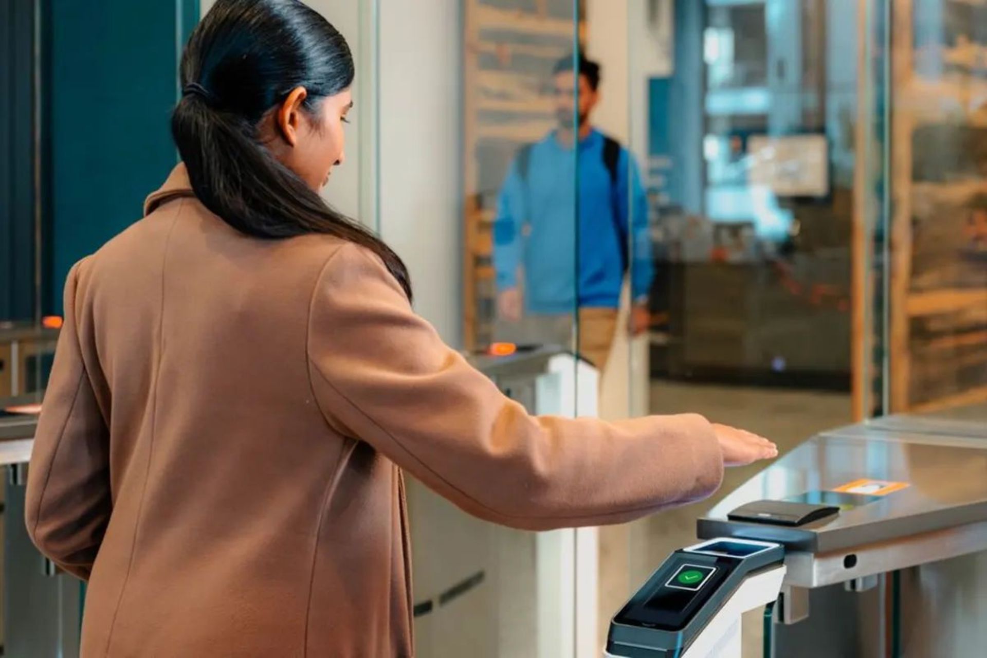 زنی درحال اسکن کف دست برای ورود به محل کار