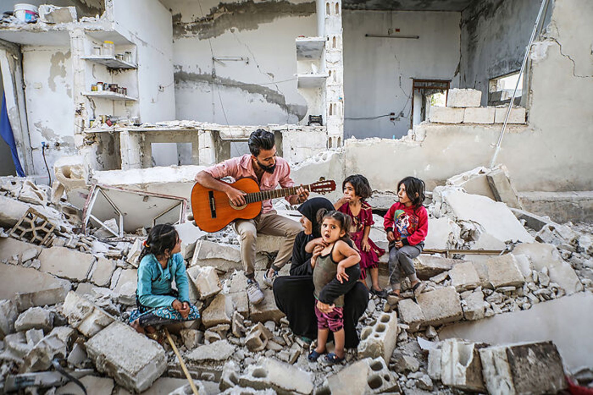 زلزله زدگان در میان آوار مرد گیتاریست و بچه ها