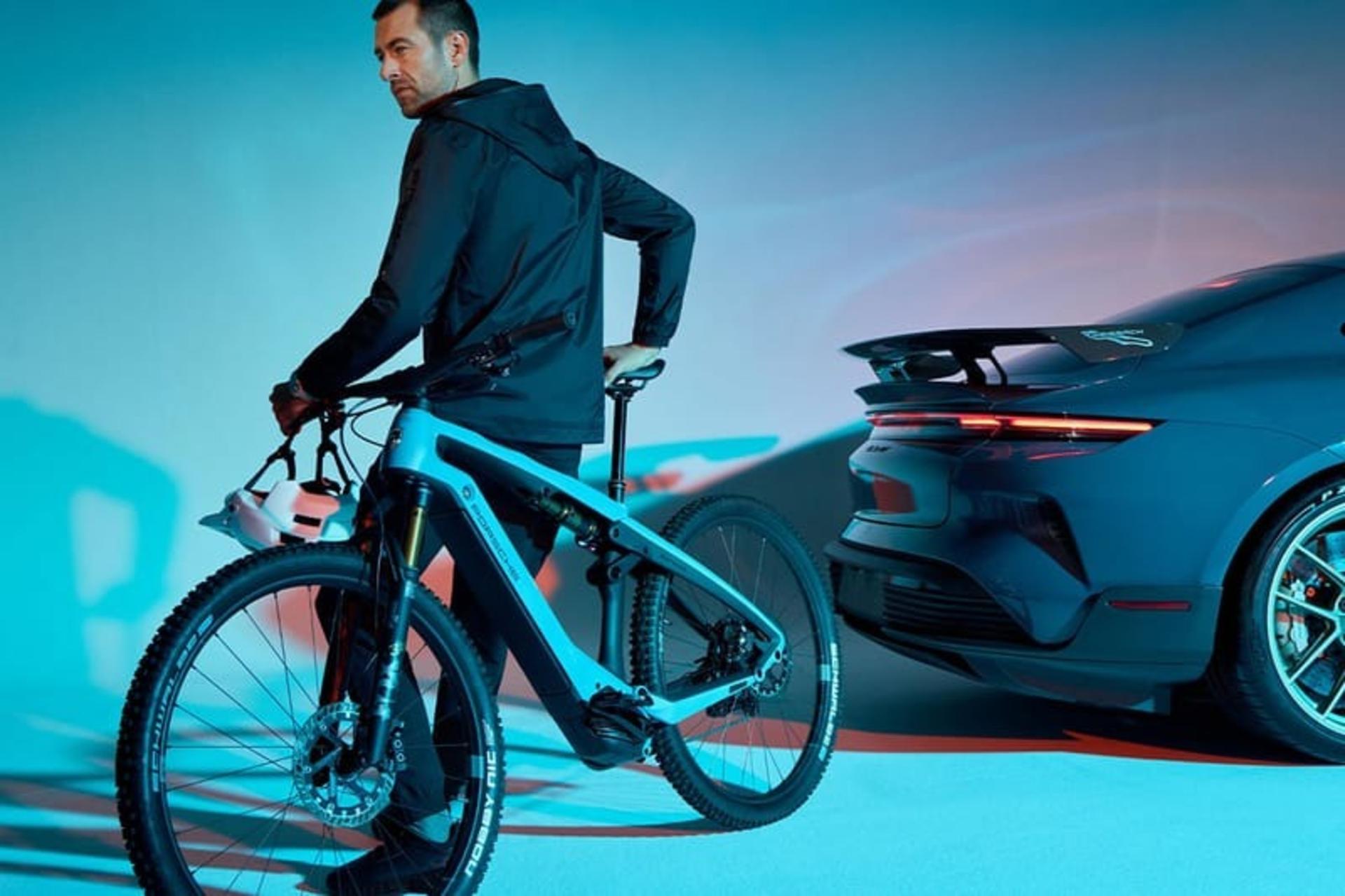 دوچرخه‌ی eBike 2025 پورشه کنار خودرو و یک مرد جوان