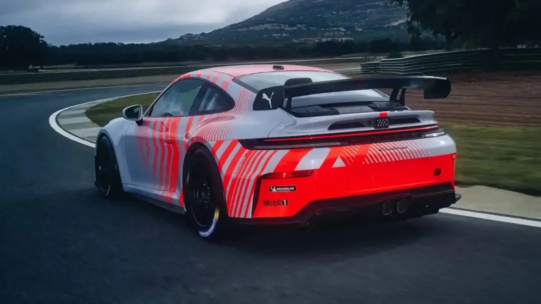 خودرو مسابقه‌ای پورشه (Porsche) با طرح گرافیکی قرمز و سفید در پیست