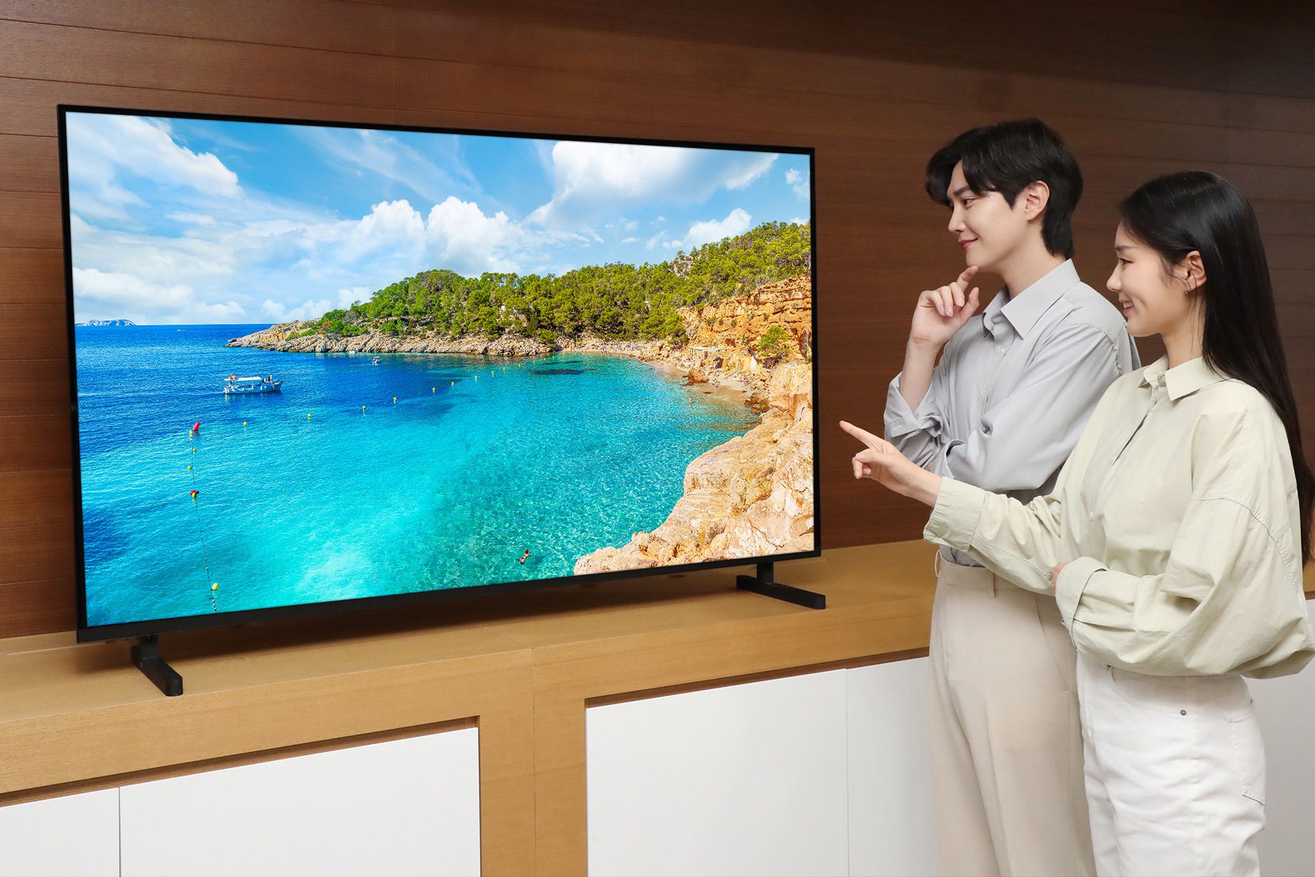 زن و مرد ایستاده در کنار تلویزیون QD-OLED سامسونگ