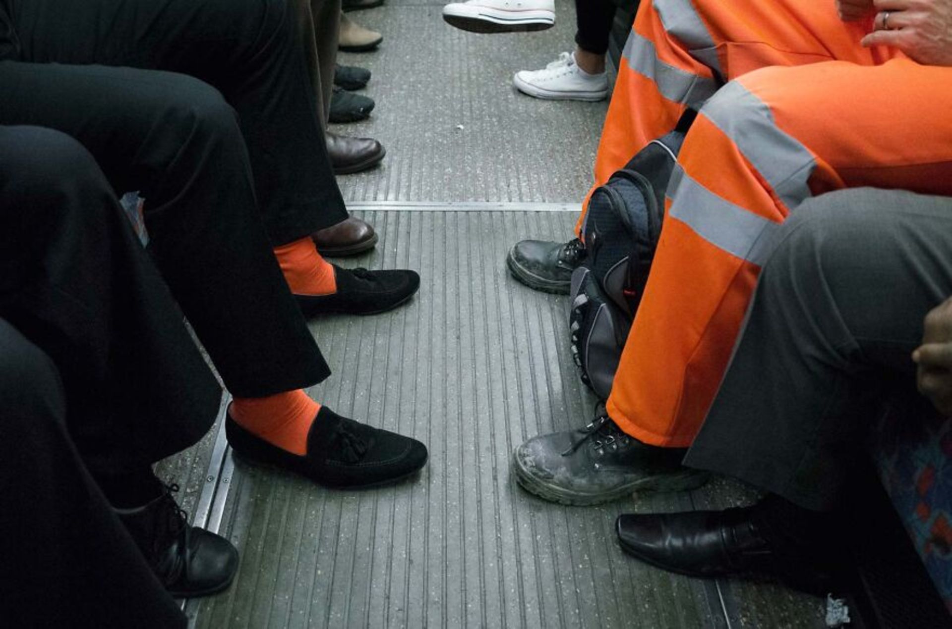 پاهای مسافران مترو مرد با لباس نارنجی و جوراب نارنجی