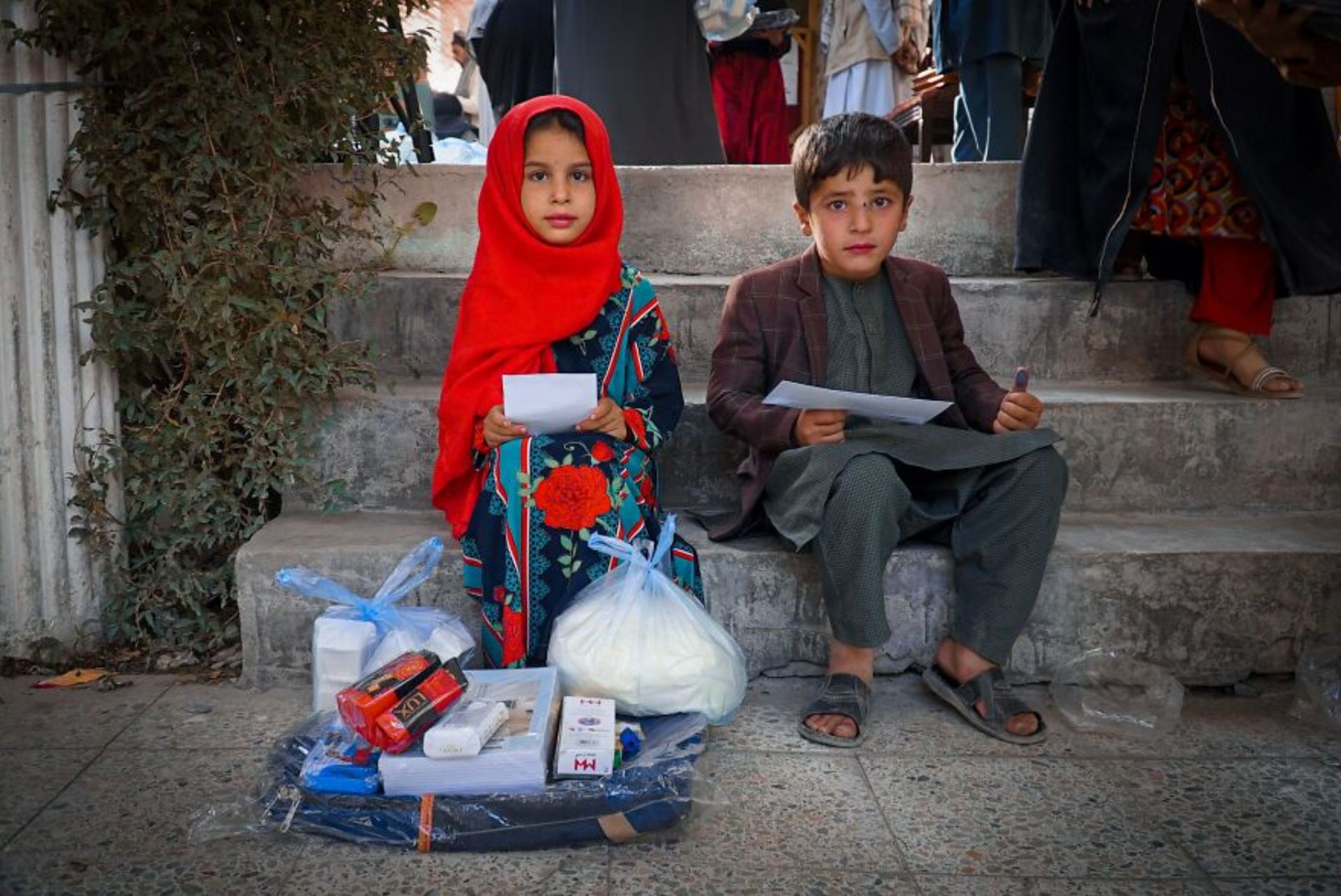 دختر و پسر افغانی روی پله بین جمعیت | دختر روسری قرمز